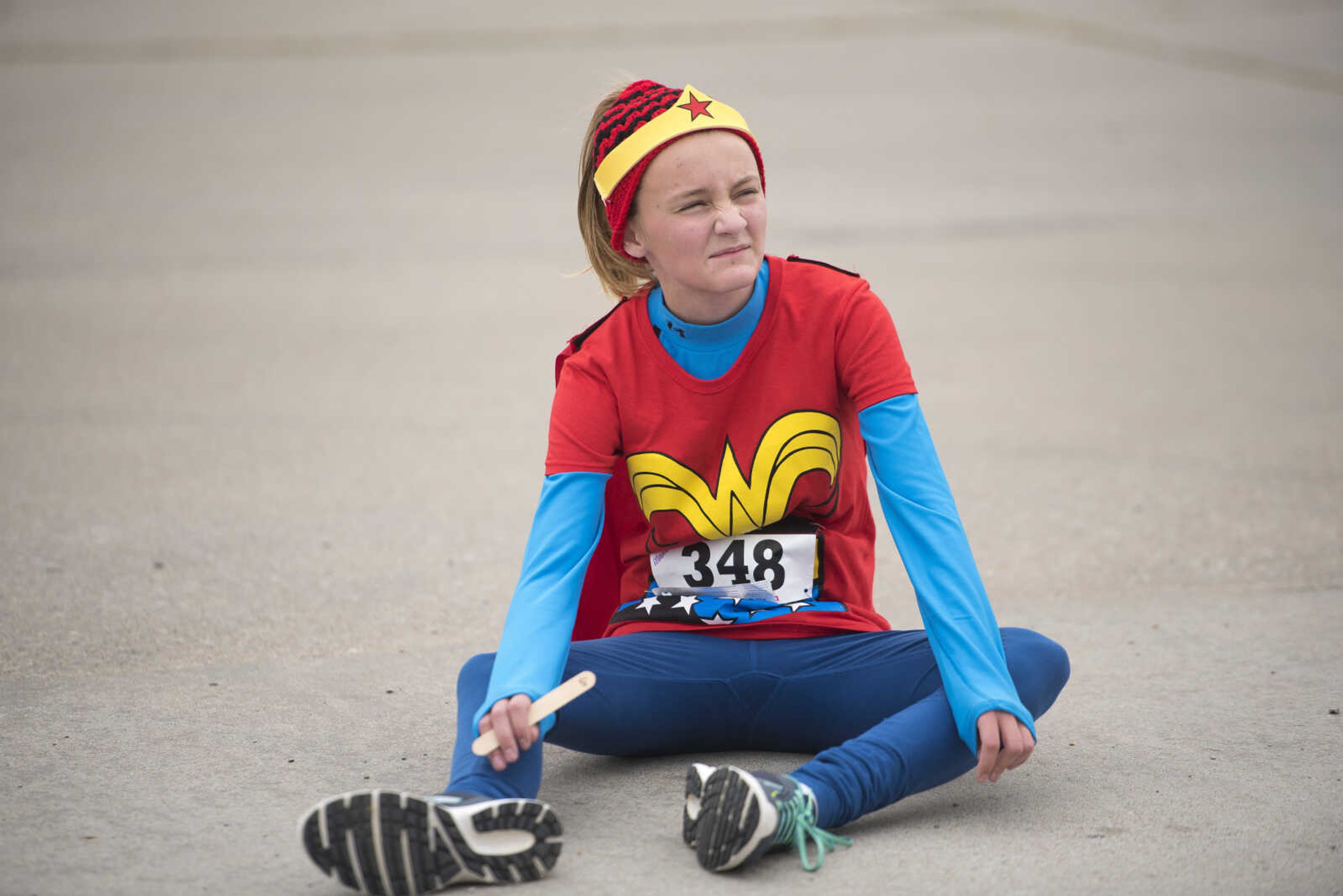 Maddie Auer sits down after running during the first Ghost and Goblin Gallop 5k race to raise money for the Crossroads Backpack Fair on Saturday, Oct. 28, 2017 in Jackson.