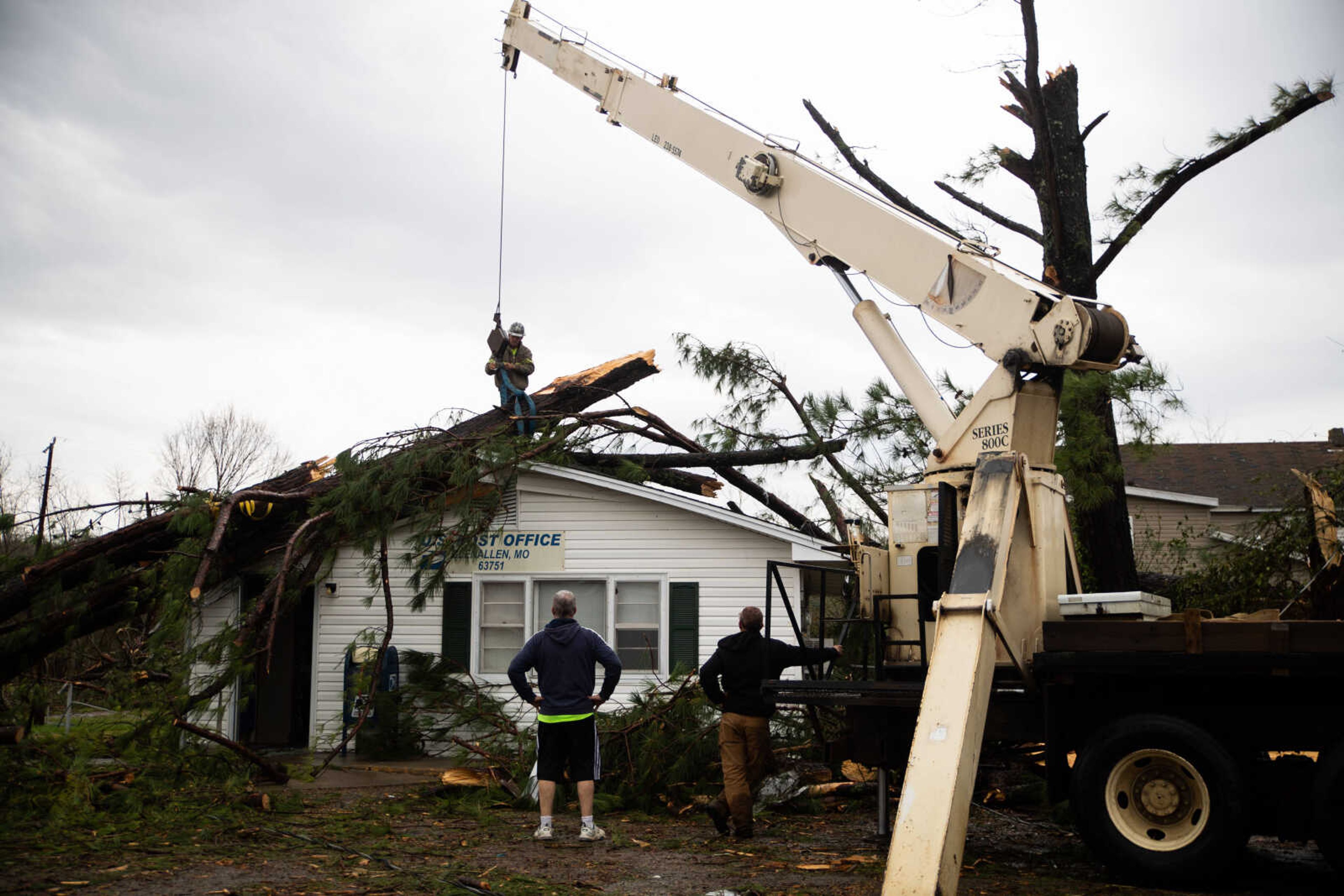 Community members watch as&nbsp;Leo Arnzen Co., a crane service out of Leopold,&nbsp;removes a tree from the roof of the Glen Allen Post Office.