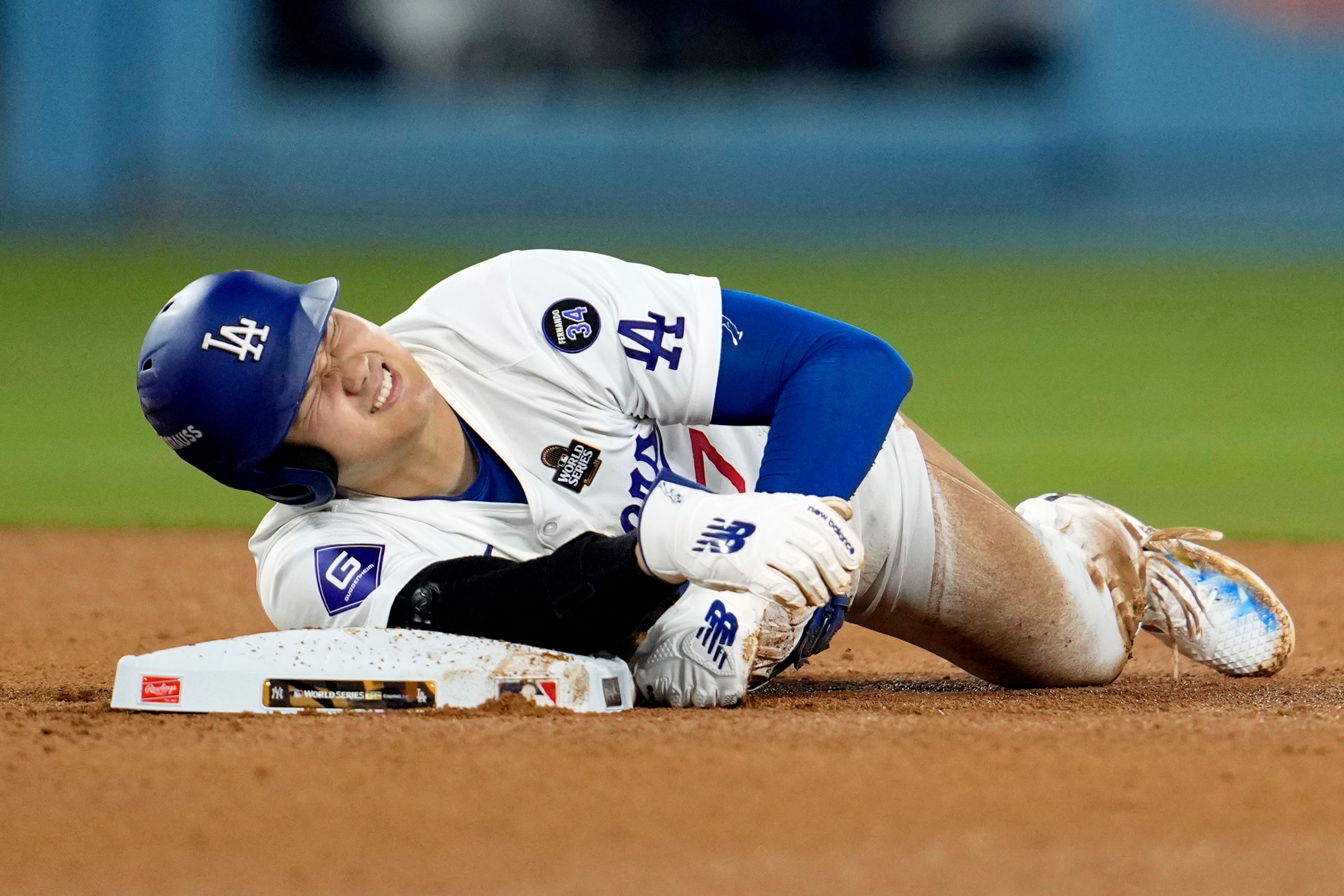 Los Angeles Dodgers' Shohei Ohtani holds his arm after being injured while trying to steal second base during the seventh inning in Game 2 of the baseball World Series against the New York Yankees, Saturday, Oct. 26, 2024, in Los Angeles. (AP Photo/Godofredo A. Vásquez)