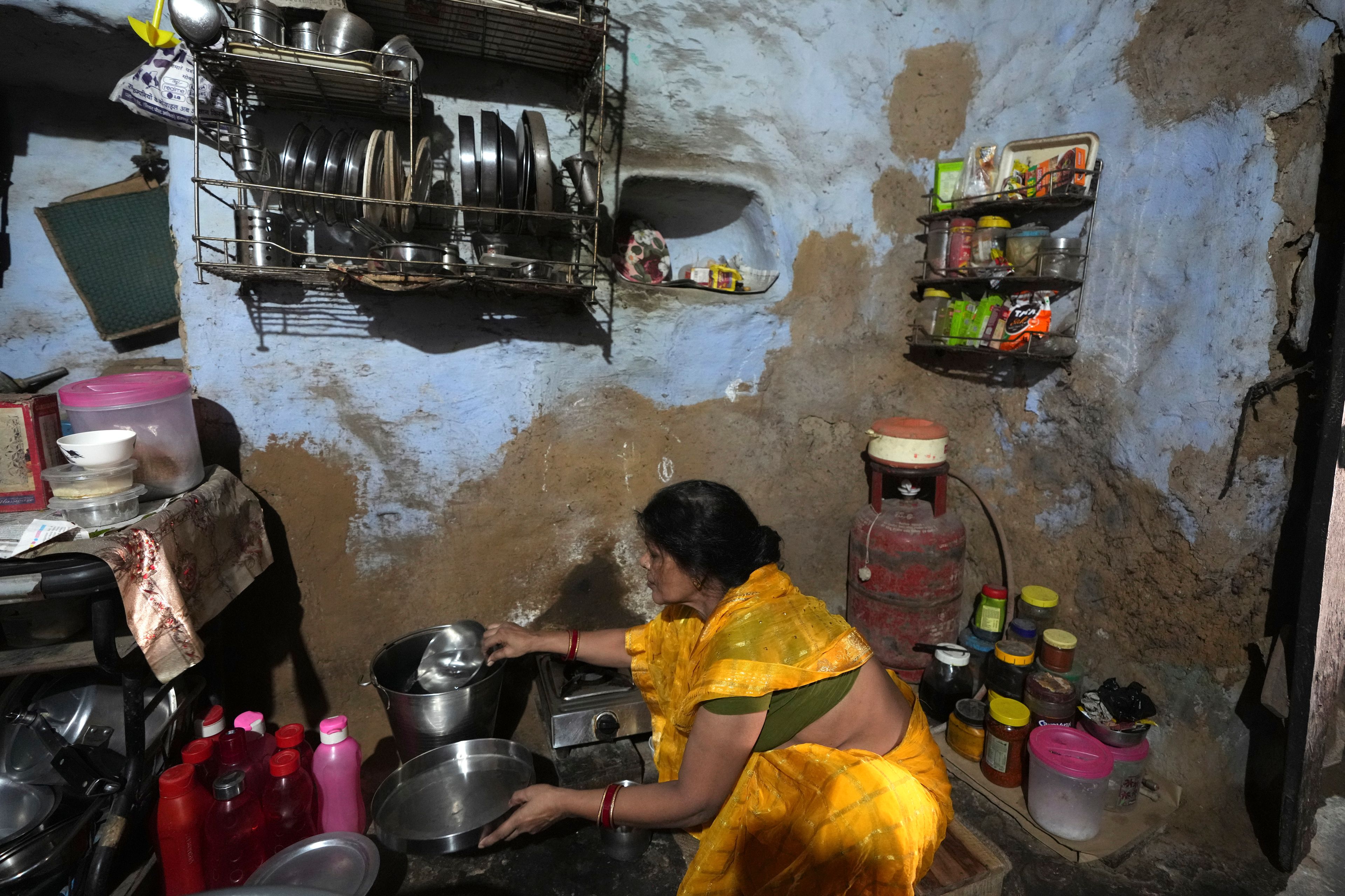 A woman works in her kitchen with steel utensils made by Tata inside her house in Prayagraj, India, Thursday, Oct. 10, 2024. (AP Photo/Rajesh Kumar Singh)