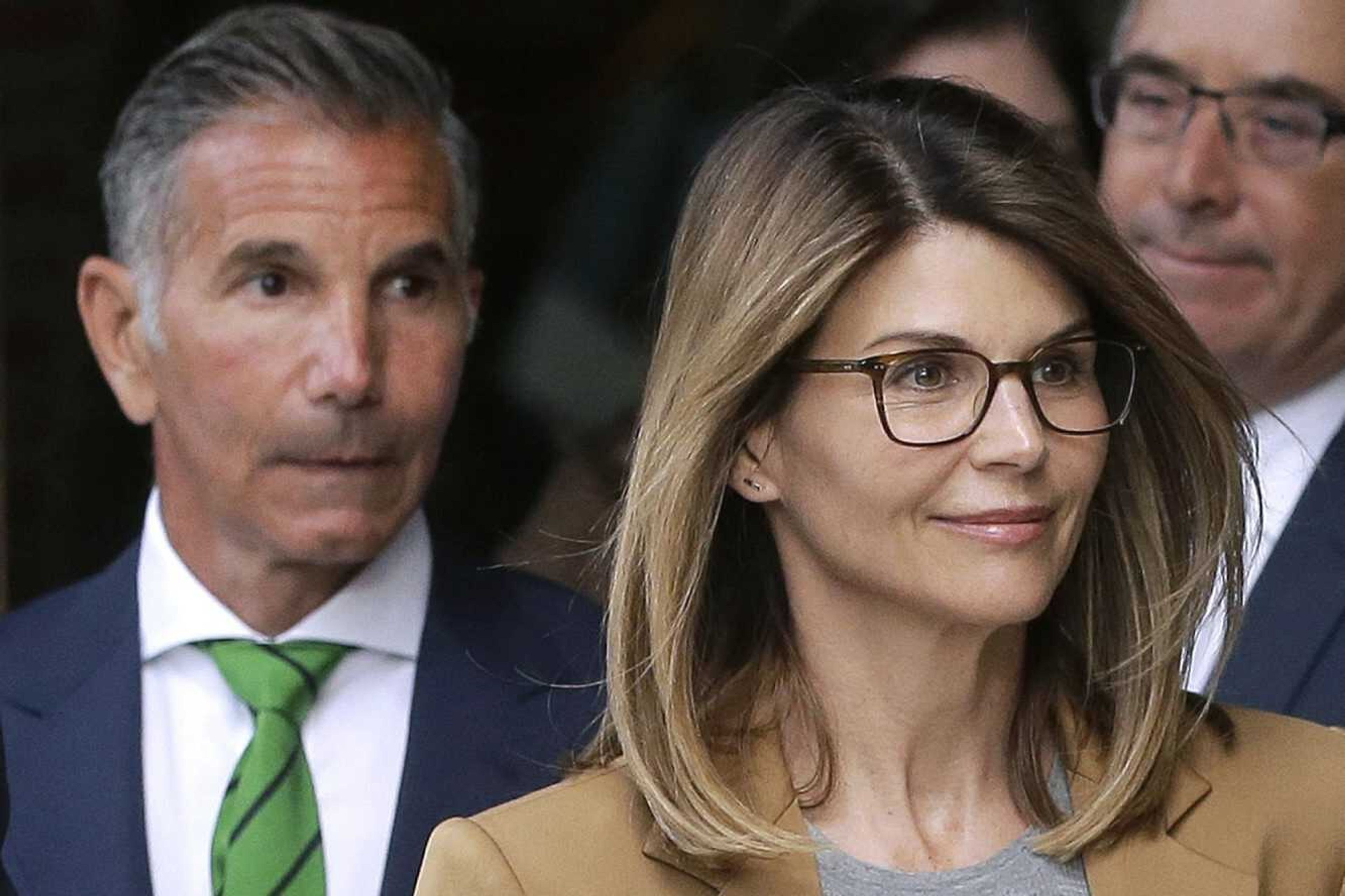 Actor Lori Loughlin, front, and husband, clothing designer Mossimo Giannulli, left, depart federal court April 3, 2019, in Boston after facing charges in a nationwide college admissions bribery scandal.