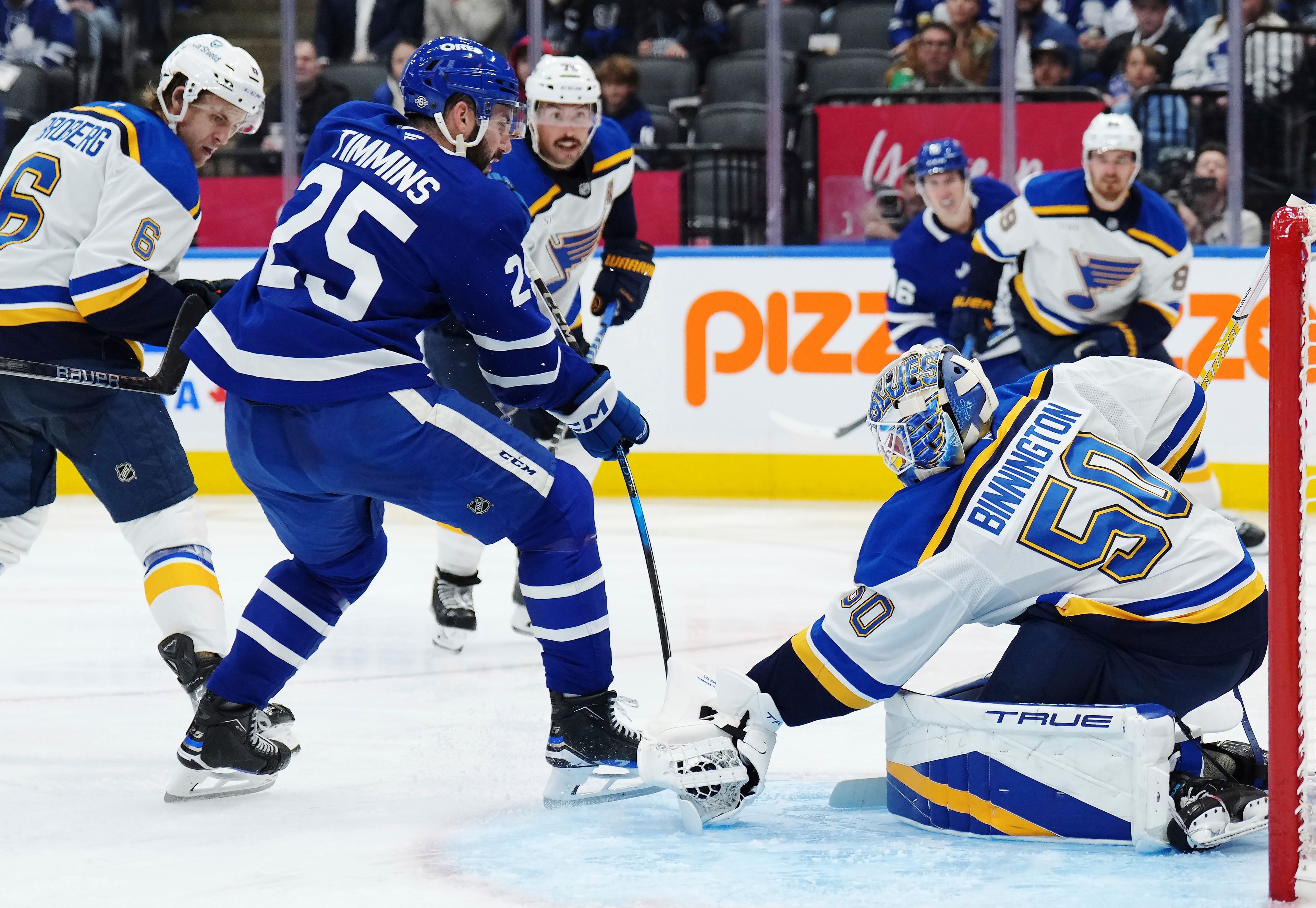 St. Louis Blues goaltender Jordan Binnington (50) stops Toronto Maple Leafs defenseman Conor Timmins (25) during second-period NHL hockey game action in Toronto, Thursday, Oct. 24, 2024. (Nathan Denette/The Canadian Press via AP)