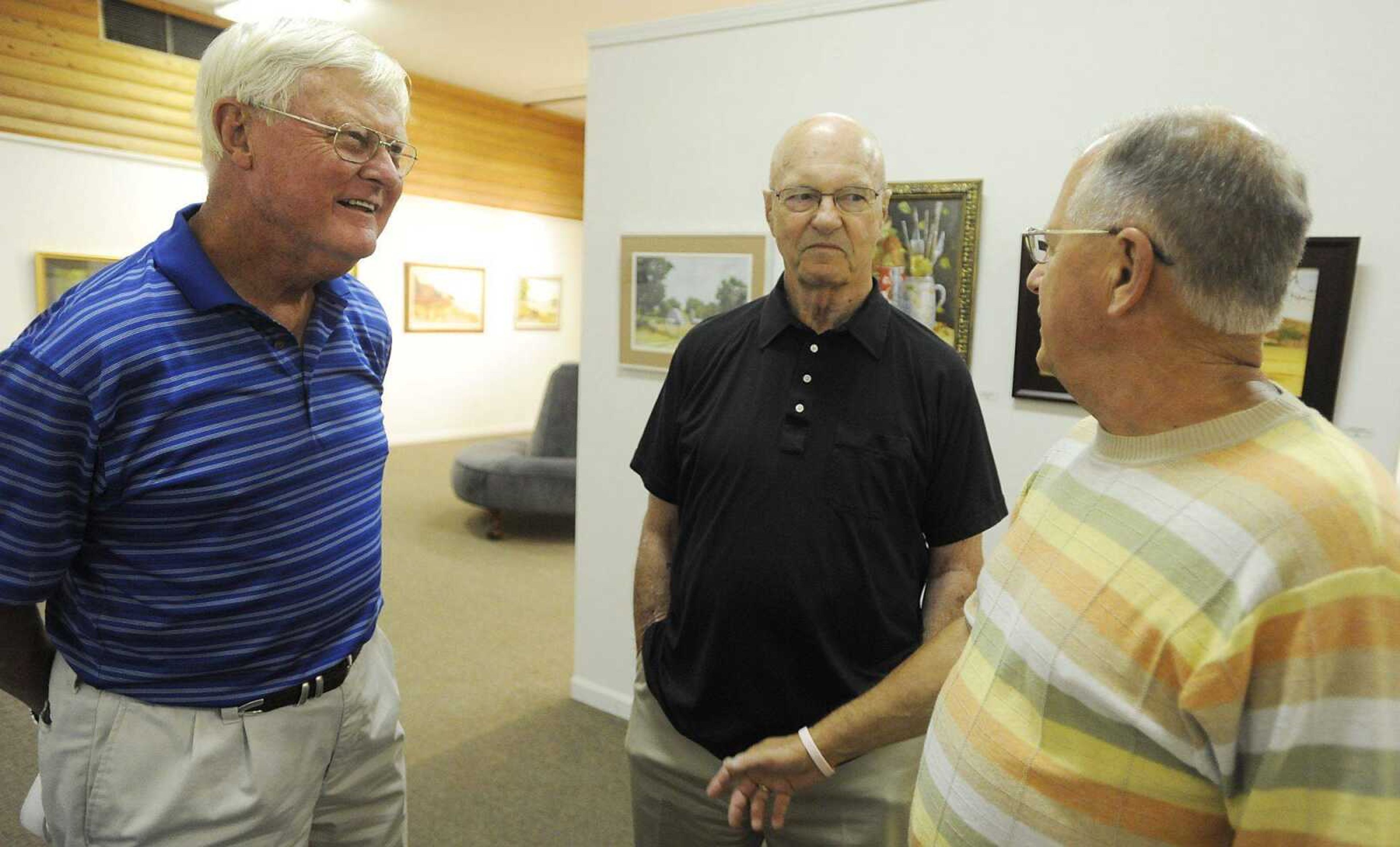 Herb Wickham, middle, talks with Dub Suedekman, left, and Jim Outman during a show of his work Friday, July 5, at the Arts Council of Southeast Missouri. The show was held as part of First Friday, where galleries in Downtown Cape Girardeau hold openings from 5 p.m to 9 p.m. with food, drink and the opportunity to talk with the artists about their work on the first Friday of each month. (Adam Vogler)