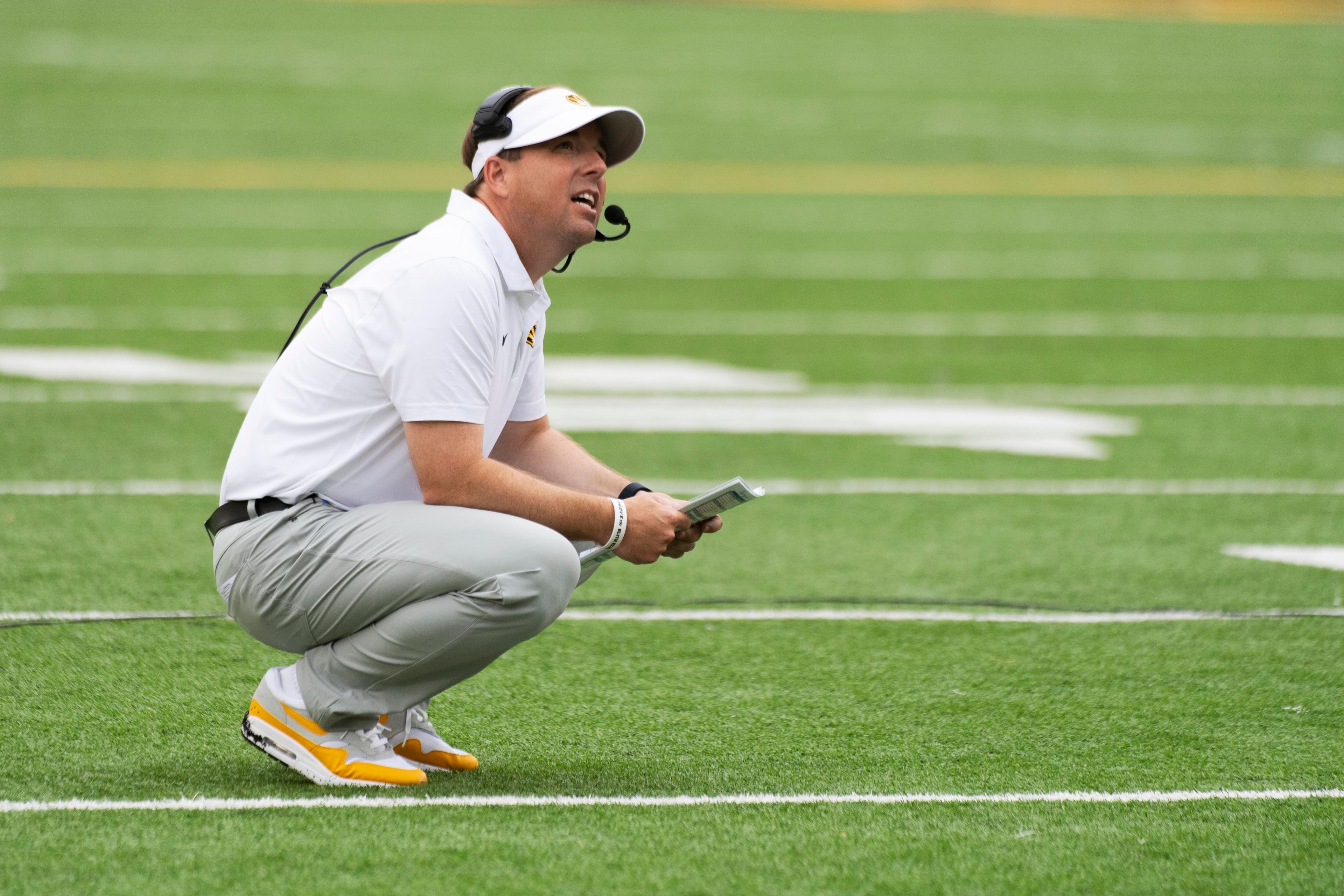 Missouri head coach Eliah Drinkwitz looks over his playbook during the first half of an NCAA college football game against Vanderbilt, Saturday, Sept. 21, 2024, in Columbia, Mo. (AP Photo/L.G. Patterson)