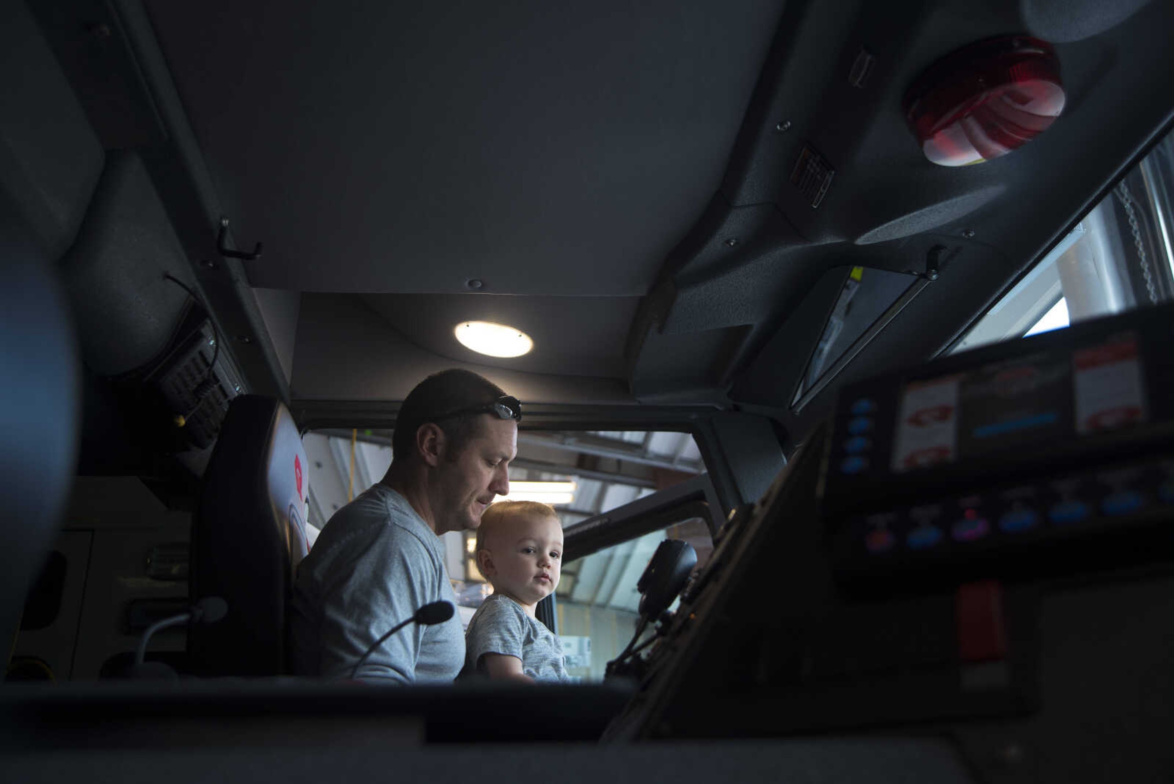 Nick Lucky and his son Asher Lucky sit in the front seat of a fire truck during the showing of the six Cape Girardeau fire trucks purchased at fire station number two Saturday, April 15, 2017 in Cape Girardeau. The National Fire Protection Association recommends fire departments to rotate their fleet every 10 years costing approximately $3.8 million dollars.