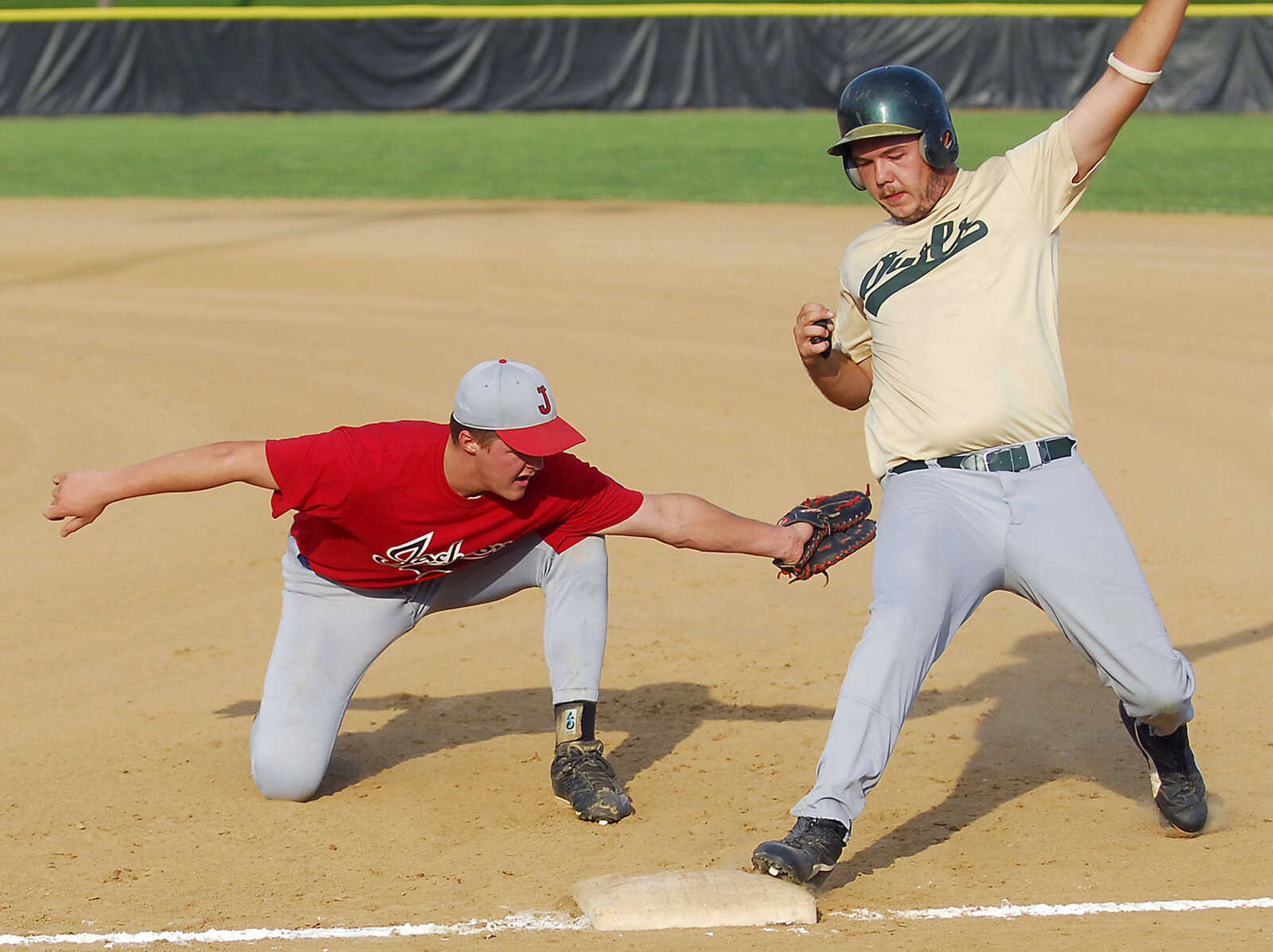 KIT DOYLE ~ kdoyle@semissourian.com
New Madrid runner Cody Cook safely squeezes around the pickoff tag from Jackson's Ryan Bass Monday evening, July 6, 2009, in a Senior Babe Ruth game at Jackson City Park.