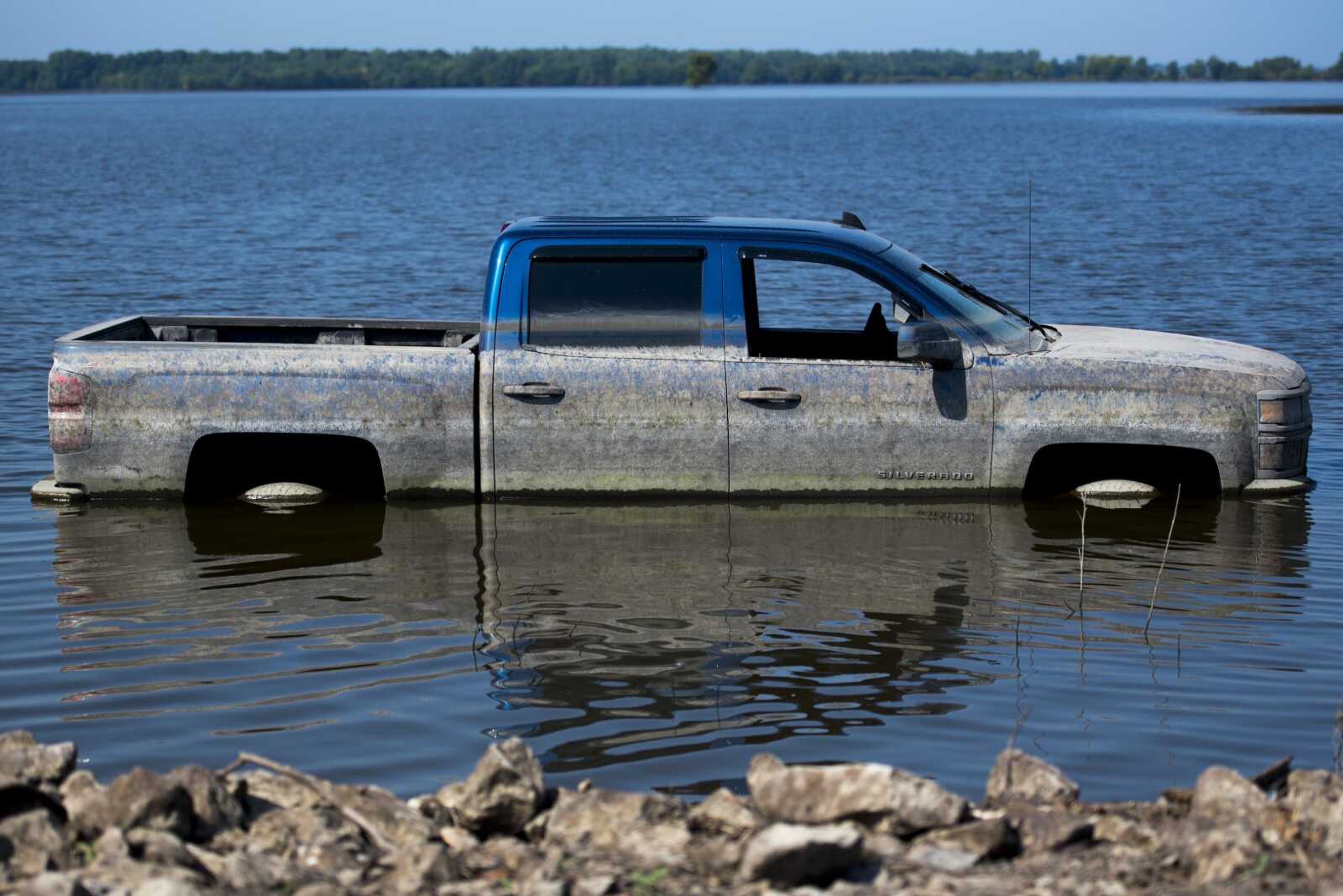 Waterlines can be seen on the side of a Chevrolet Silverado parked in receding floodwaters Sunday in McClure, Illinois.