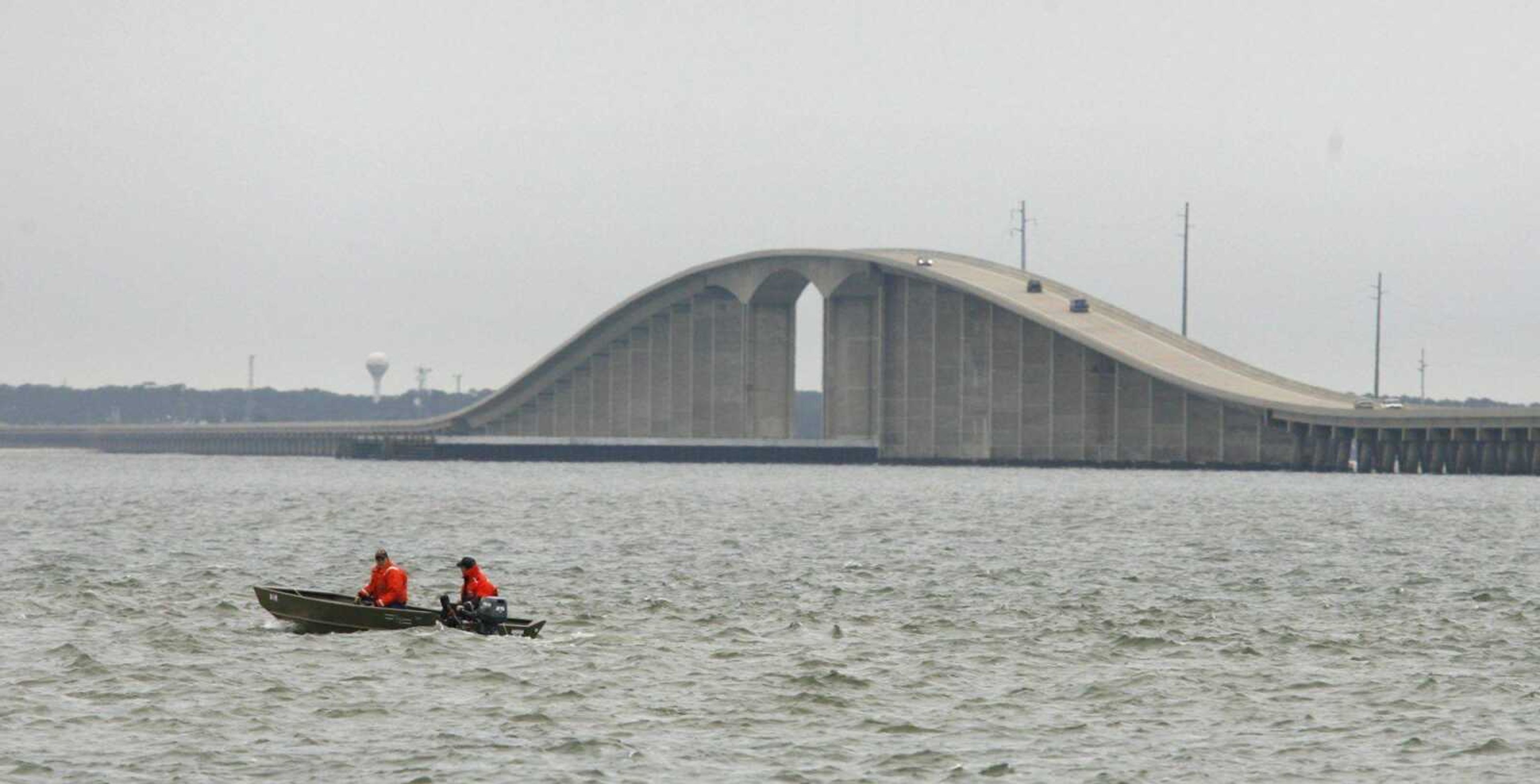 Two members of the U.S. Coast Guard searched the water north of the Dauphin Island Bridge Wednesday in Mobile County, Ala. A local fisherman, Lam Luong, 37, who said he threw his four children from the bridge Monday morning was charged with four counts of capital murder. (Bill Starling ~ Press-Register)