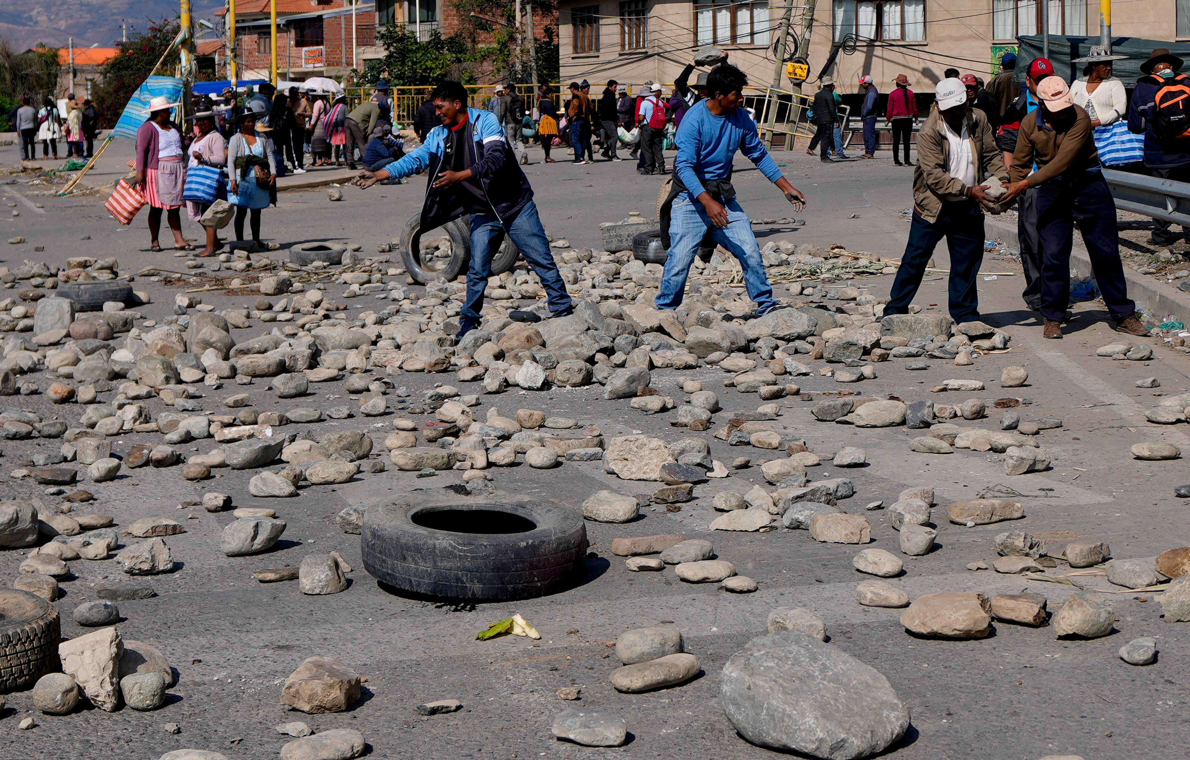 Supporters of Bolivian former President Evo Morales block a road with stones to prevent him from facing a criminal investigation over allegations of abuse of a minor and to demonstrate against an alleged assassination attempt, near Cochabamba, Bolivia, Monday, Oct. 28, 2024. (AP Photo/Juan Karita)