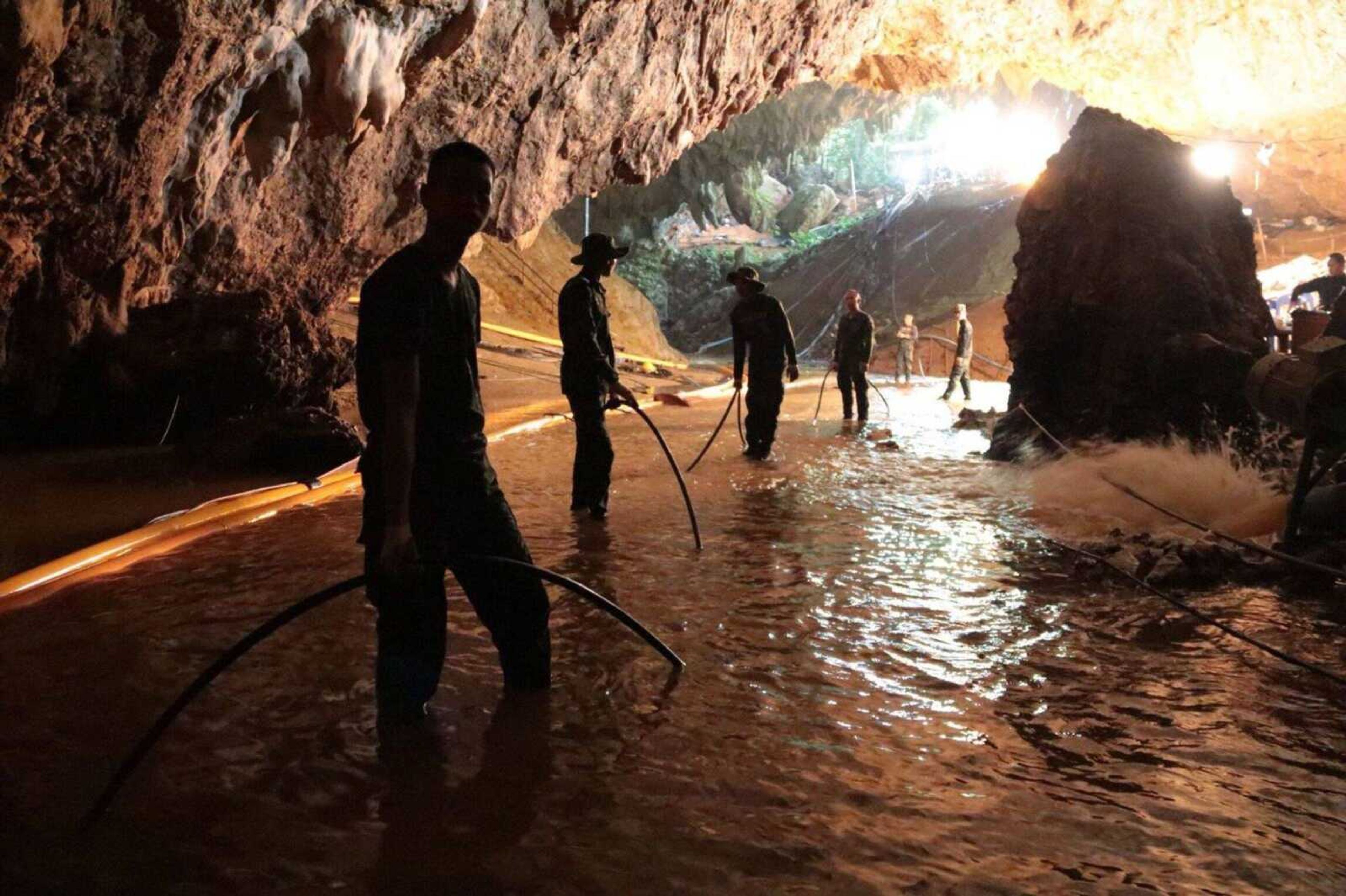 In this undated photo, Thai rescue teams arrange water pumping system at the entrance to a flooded cave complex where 12 boys and their soccer coach have been trapped since June 23, in Mae Sai, Chiang Rai province, northern Thailand.