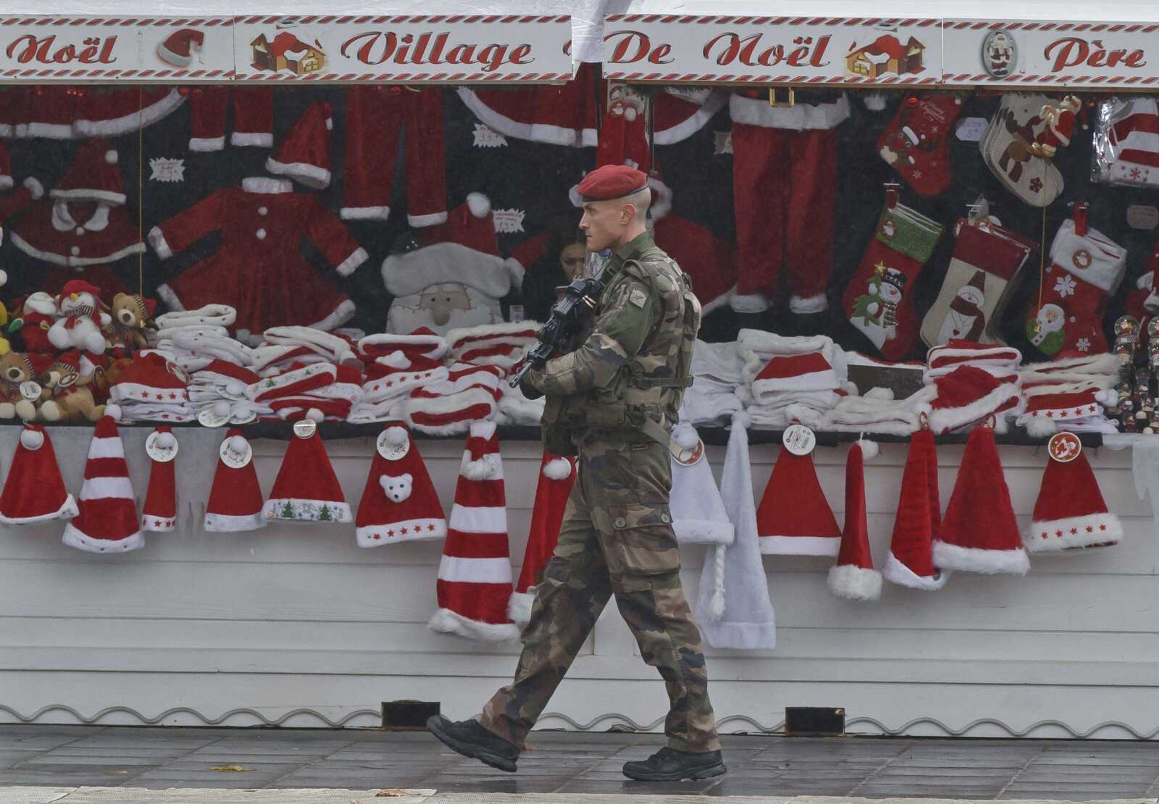 A soldier patrols Tuesday at the Christmas market along the Champs Elysees avenue in Paris. (Michel Euler ~ Associated Press)