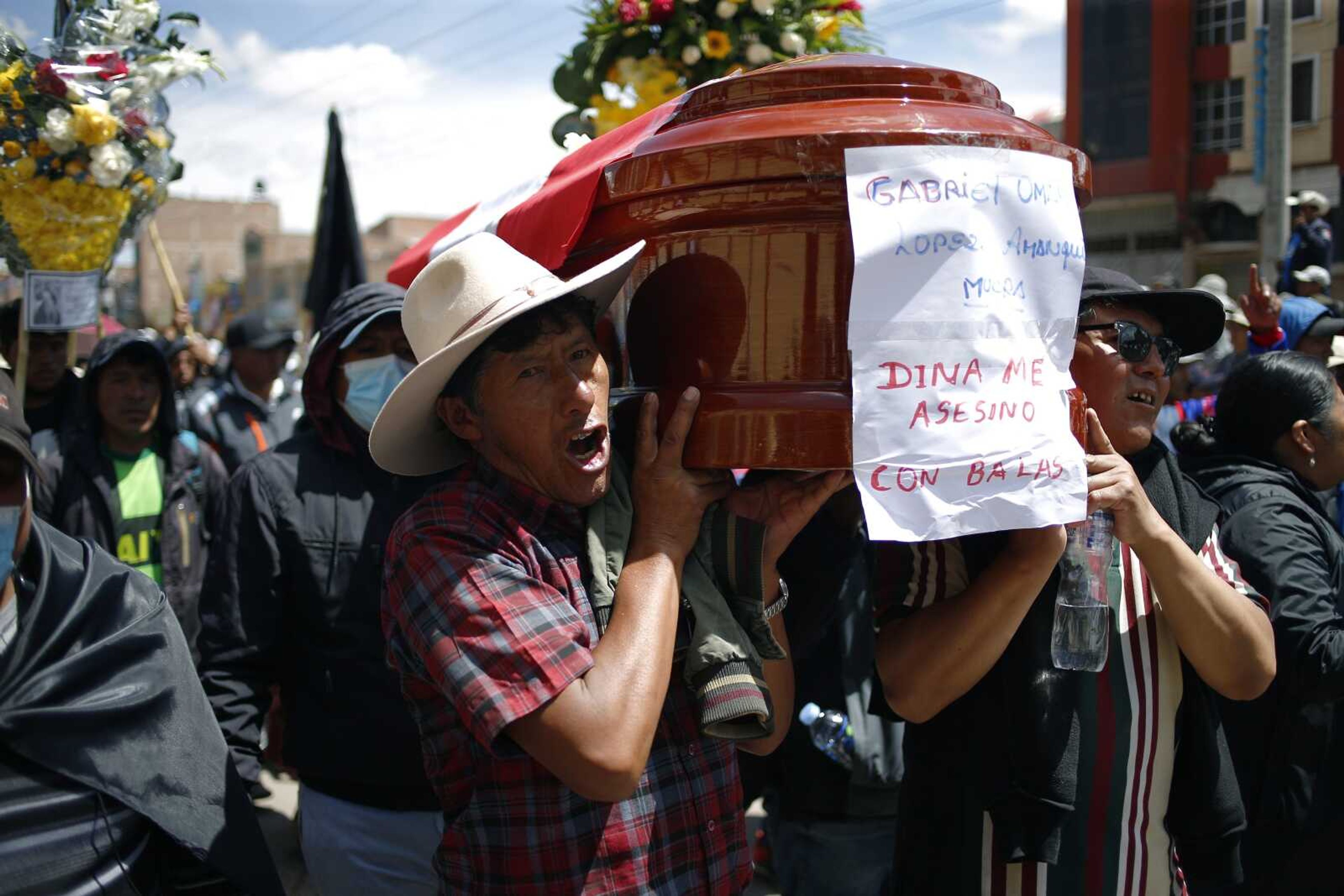 Residents carry a coffin with the name of the deceased and Spanish message: "Dina killed me with bullets", referring to President Dina Boluarte, on Wednesday during a funeral procession for protesters and others killed during clashes with police in Juliaca, Peru. At least 17 people died Monday in southeast Peru as protests seeking immediate elections resumed in rural areas of the country still loyal to ousted President Pedro Castillo.