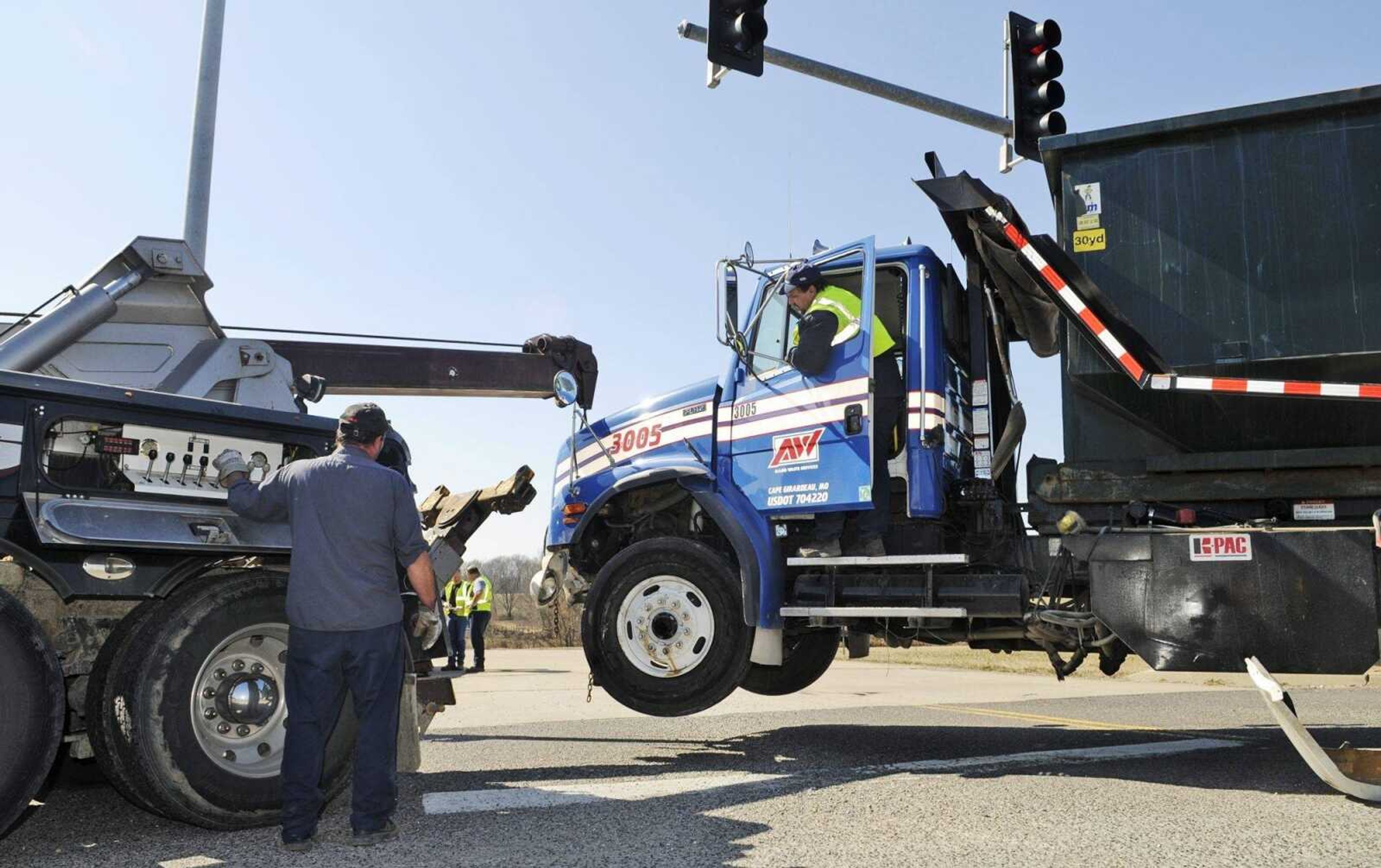 Workers pull a damaged dump truck onto a tow truck after an accident at the Route 61 Route 177 intersection in Fruitland, Mo., on Friday, March 5, 2010. A car traveling north on Route 61 collided with a dump truck that was passing through a green light at the intersection on Route 177. The female driver of the car was taken to the hospital, but her child passenger and the dump truck driver were not injured. (Kristin Eberts)