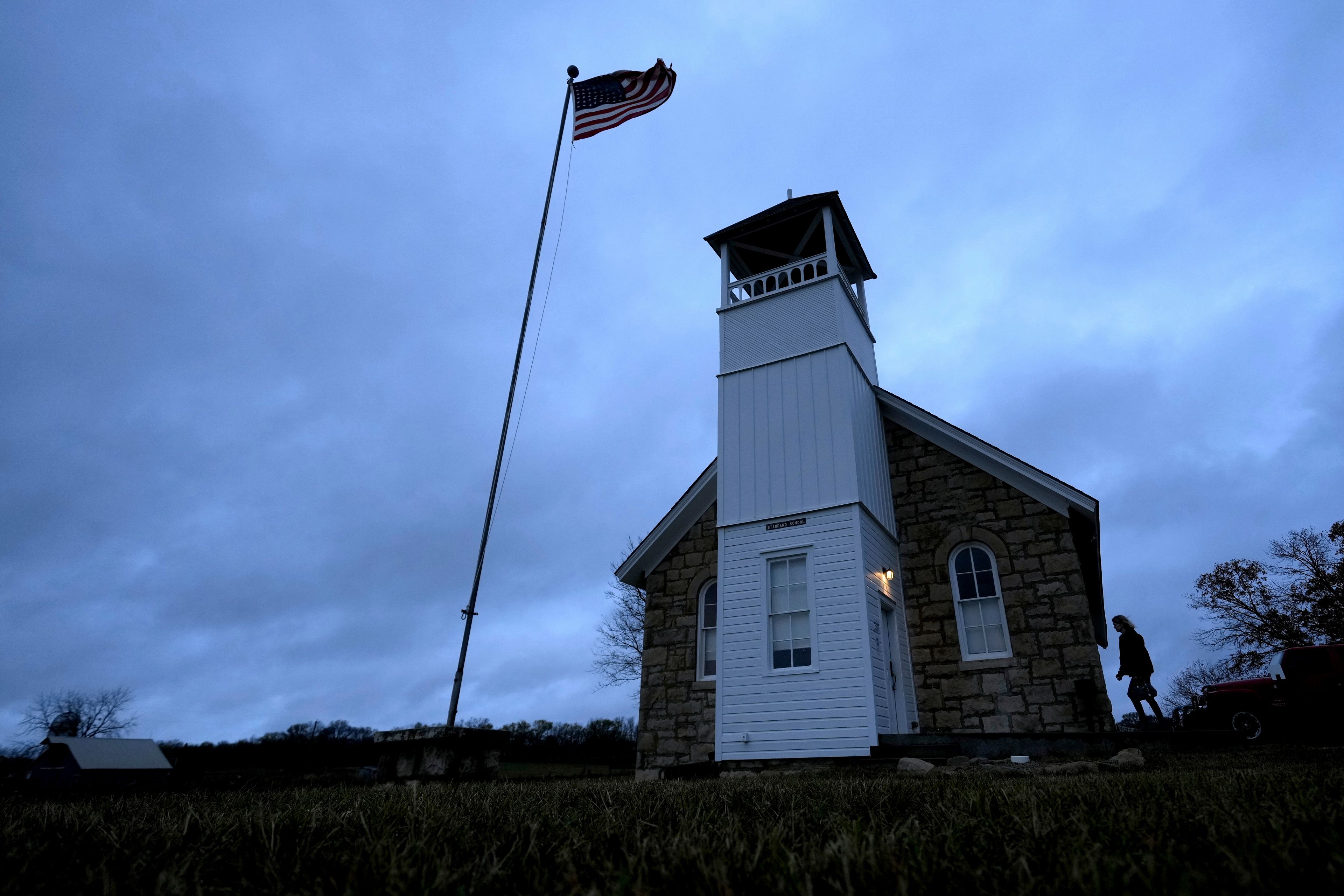 A voter arrives at the 146-year-old Buck Creek school to cast their ballot on Election Day, Tuesday, Nov. 5, 2024, in rural Perry, Kan. (AP Photo/Charlie Riedel)