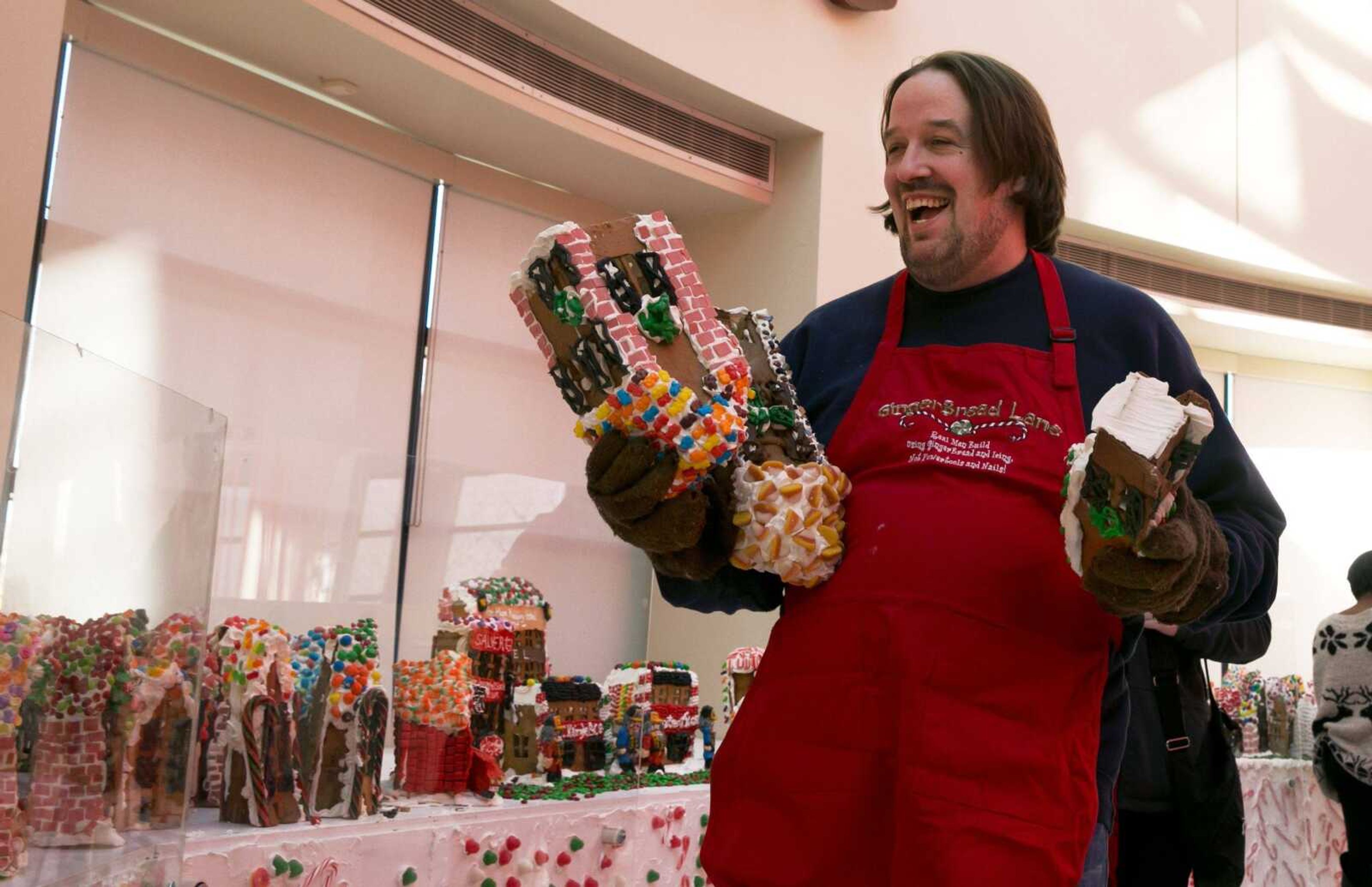 Chef Jon Lovitch carries some of his gingerbread house creations for the GingerBread Lane display, at the New York Hall of Science, in the Queens borough of New York, Thursday, Nov. 13, 2014. Lovitch, a Manhattan chef who holds the Guinness record for creating the world s largest collection of gingerbread houses, is now going for another record, competing against himself by assembling more than 1,000 new ones. (AP Photo/Richard Drew)