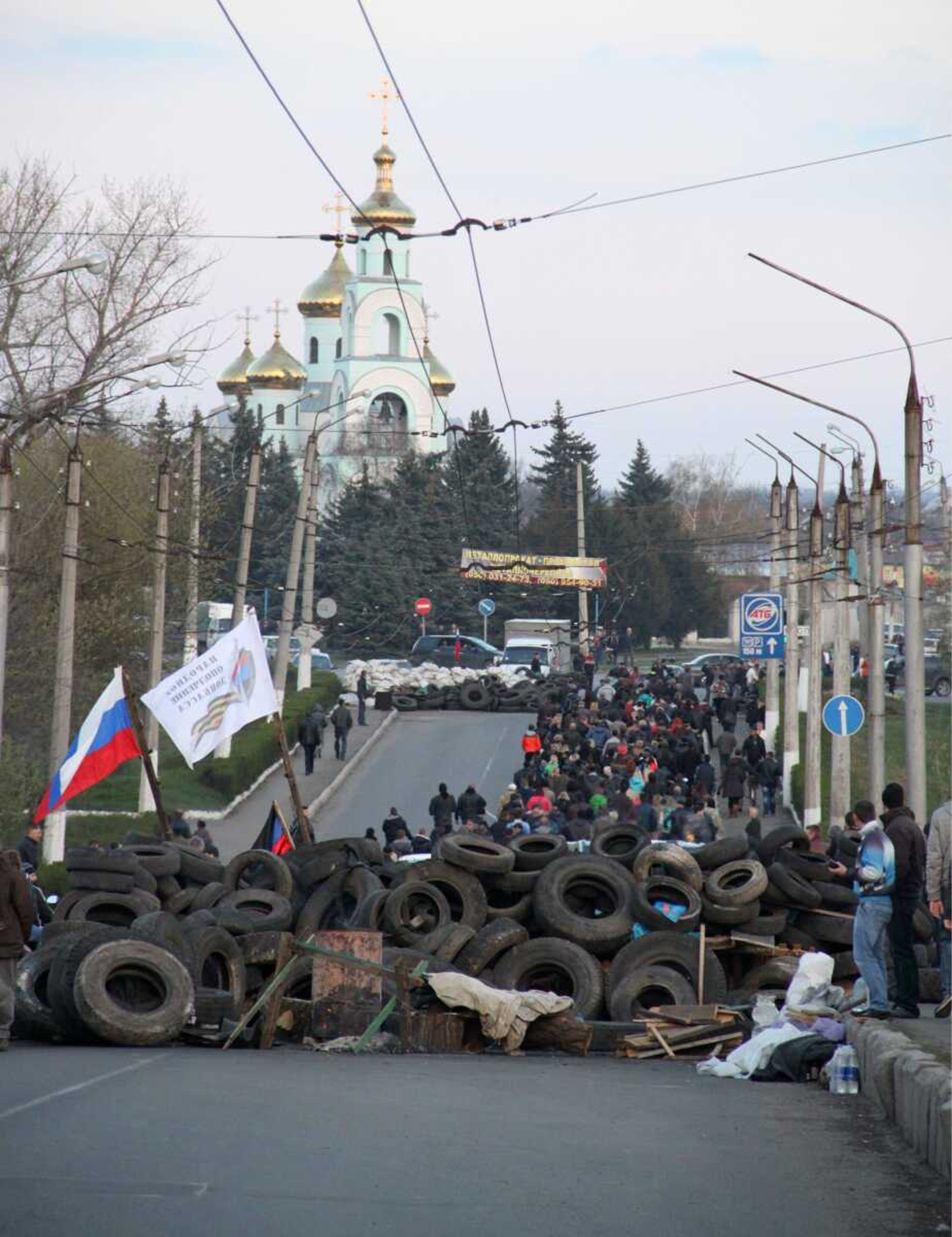 Pro-Russian people walk towards the airport Tuesday in Kramatorsk, Ukraine. In the first Ukrainian military action against a pro-Russian uprising in the east, government forces clashed Tuesday with about 30 armed gunmen at the small airport there. (Alexander Ermochenko ~ Associated Press)