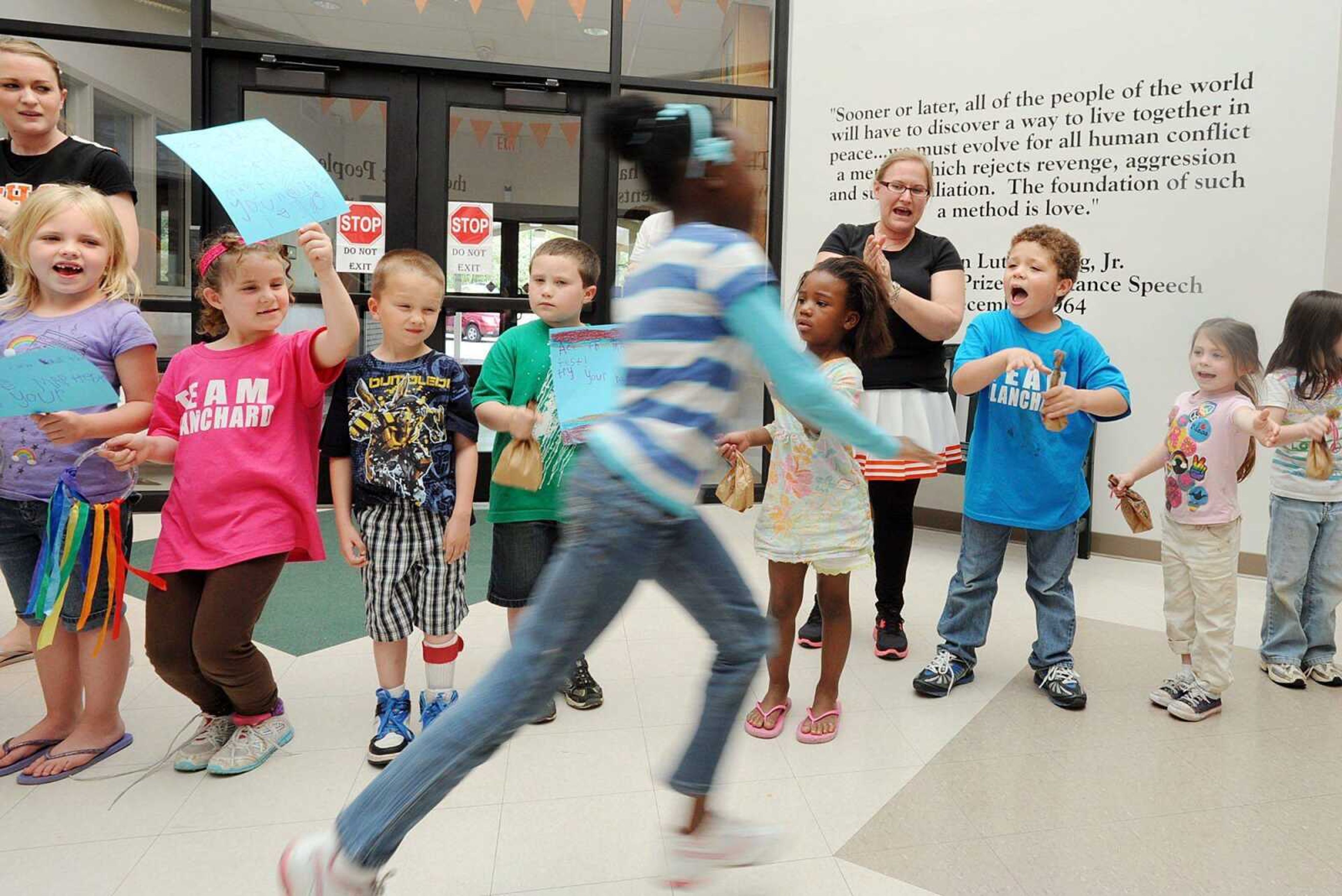 Blanchard Elementary kindergarten students line the entrance to the school while yelling &#8220;Pass the test!&#8221; as fellow students run the halls April 4 to get pumped about the upcoming MAP tests. (Laura Simon)