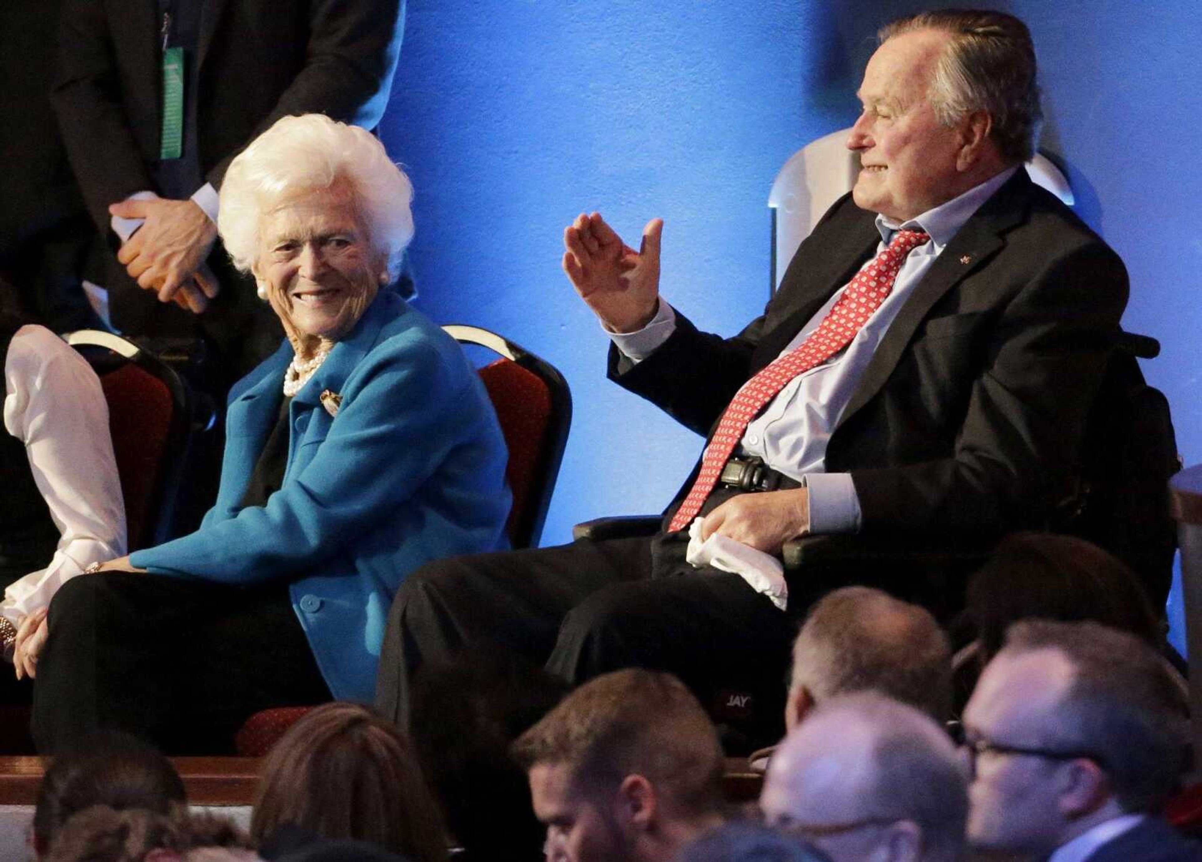 Former president George H. W. Bush and his wife, Barbara, are greeted Feb. 25 before a Republican presidential primary debate at the University of Houston.