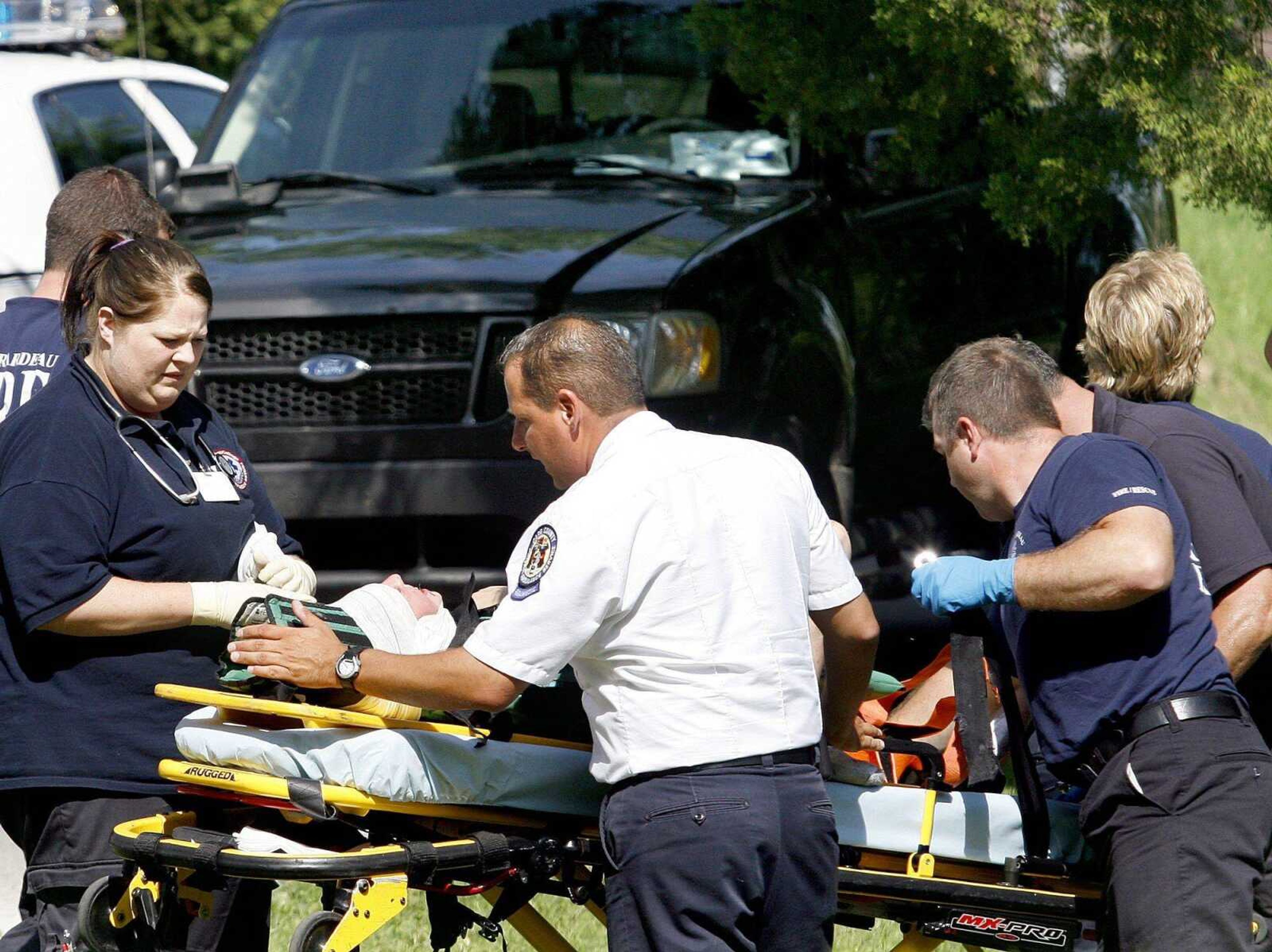 Firefighters and paramedics help a 10-year-old boy into an ambulance after he was struck by a vehicle Friday on Capaha Trail. (Elizabeth Dodd)