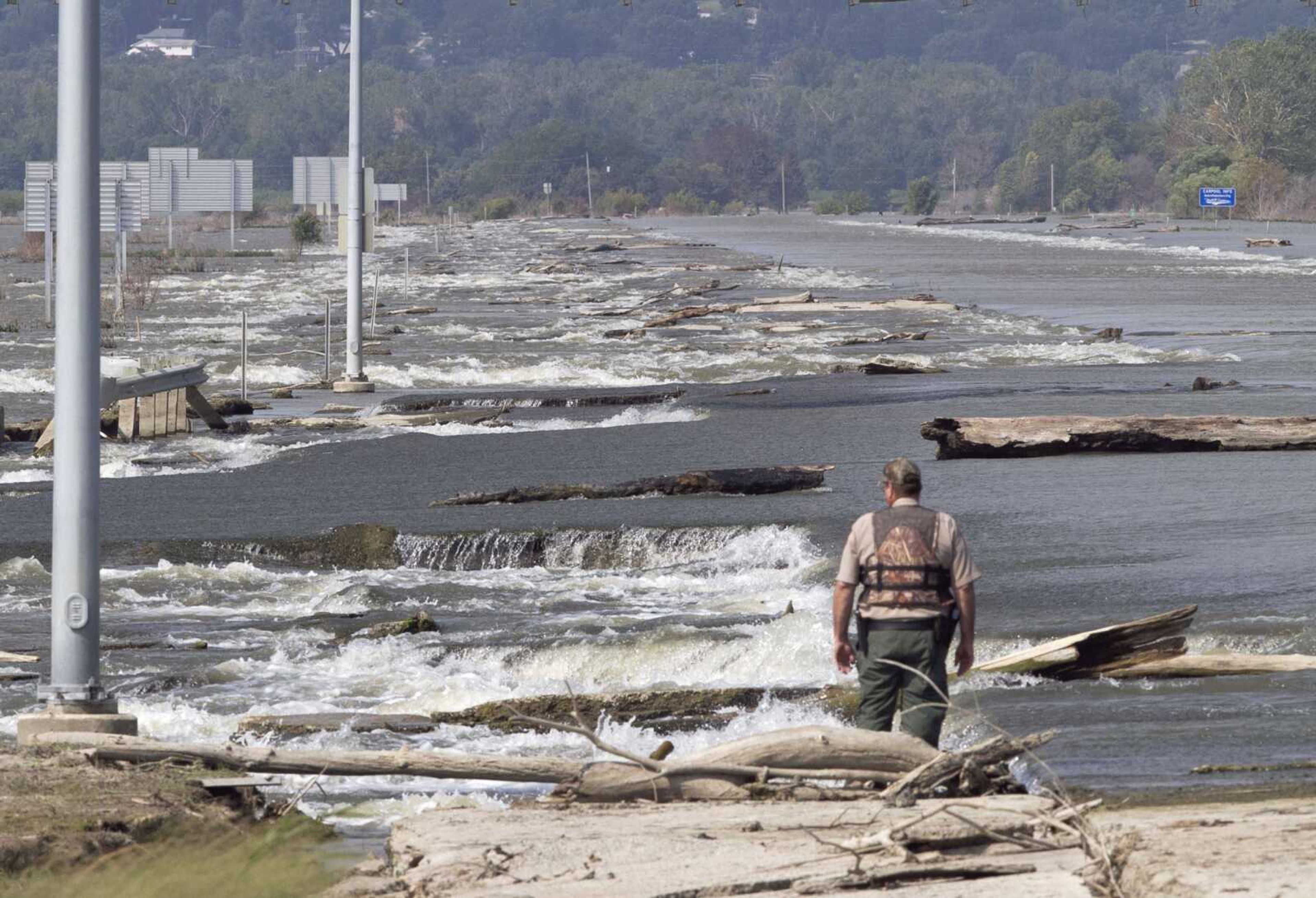 Mark Sedlmayr, conservation officer with the Iowa Department of Natural Resources, surveys damage and debris Thursday on Interstate 680 near Crescent, Iowa. Rep. Steve King, R-Iowa, organized a boat tour Thursday to inspect damage caused by the ongoing flooding of the Missouri River. (Nati Harnik ~ Associated Press)