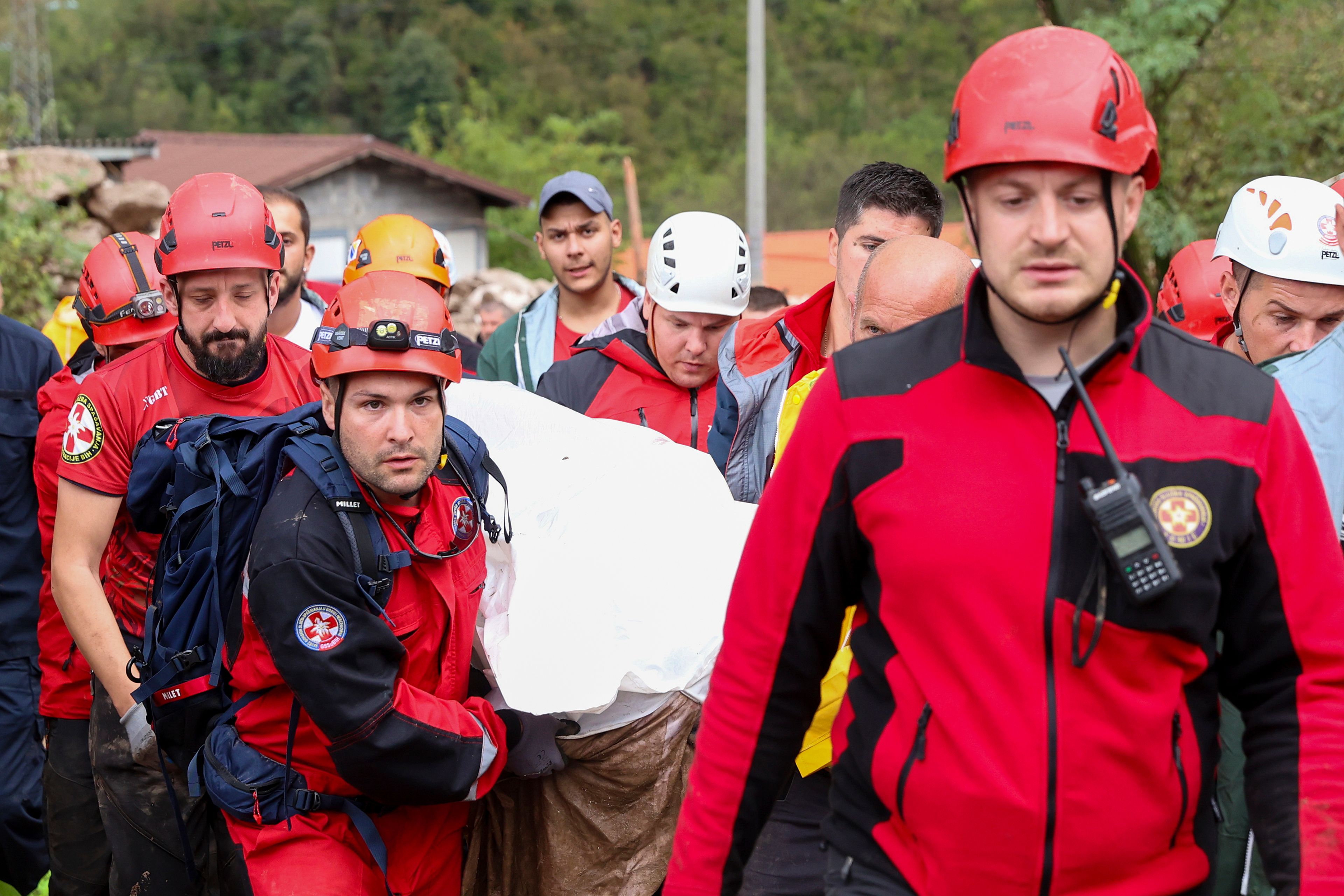 Members of the mountain rescue service carry a body of a person killed by a landslide in the flooded village of Donja Jablanica, Bosnia, Saturday, Oct. 5, 2024. (AP Photo/Armin Durgut)