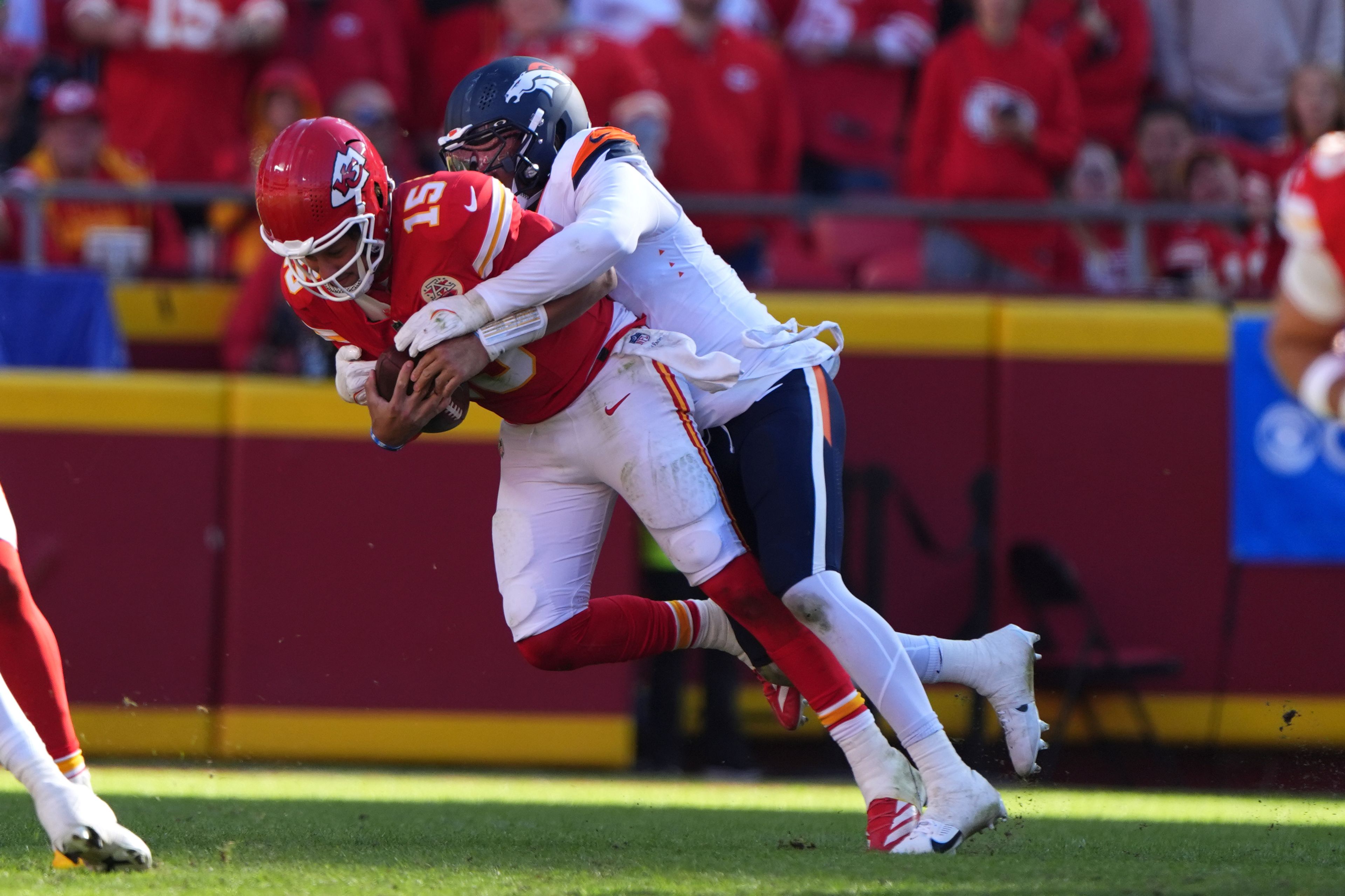 Kansas City Chiefs quarterback Patrick Mahomes (15) is sacked for a 9-yard loss by Denver Broncos outside linebacker Nik Bonitto during the second half of an NFL football game Sunday, Nov. 10, 2024, in Kansas City, Mo. (AP Photo/Charlie Riedel)