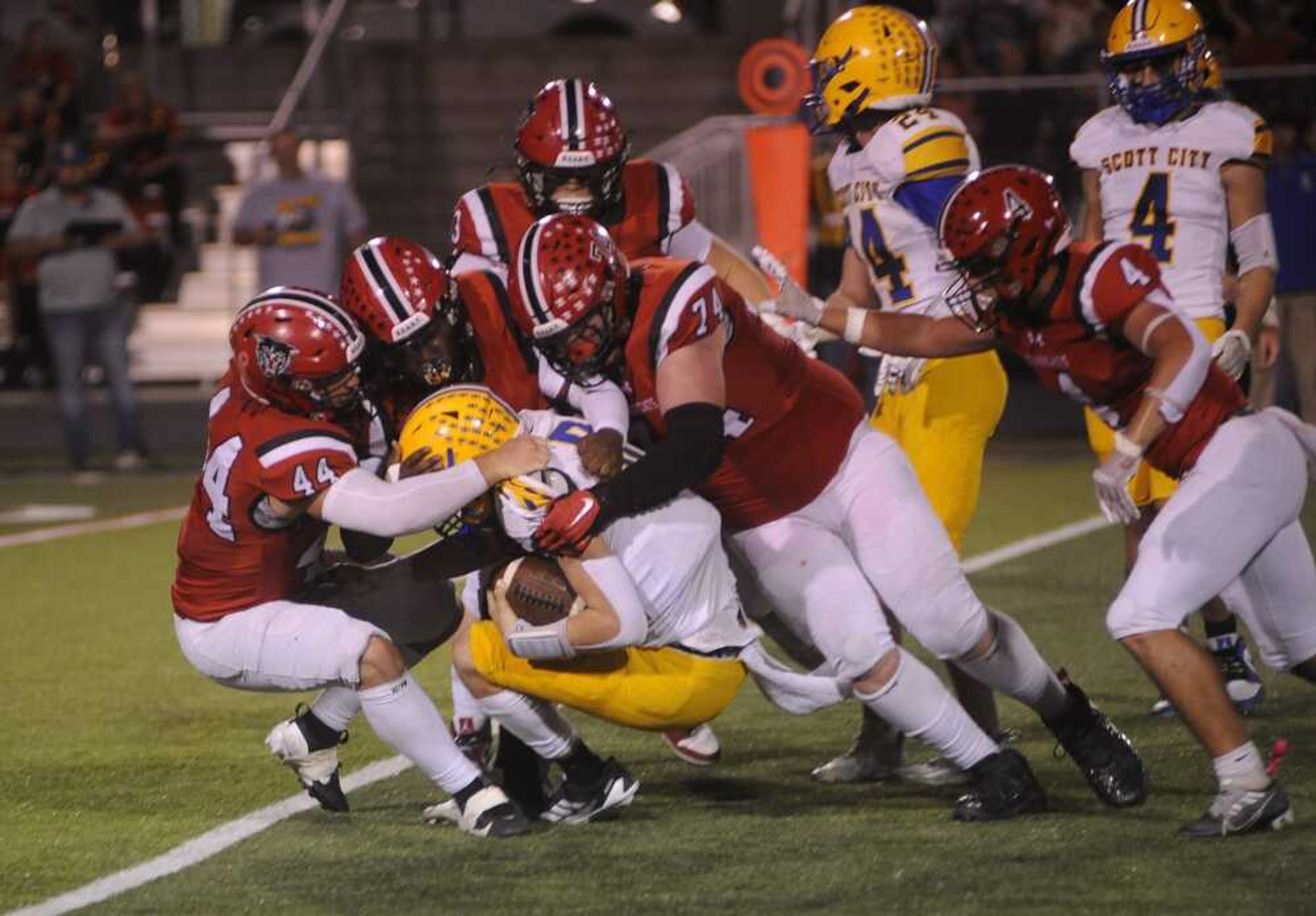 Dexter defenders, from left, Jason Hervoyavich, Travis Robinson, and Ethan Glaus tackle Scott City quarterback Jackson Gloth on Friday, Oct. 25, at Charles Bland Stadium in Dexter.