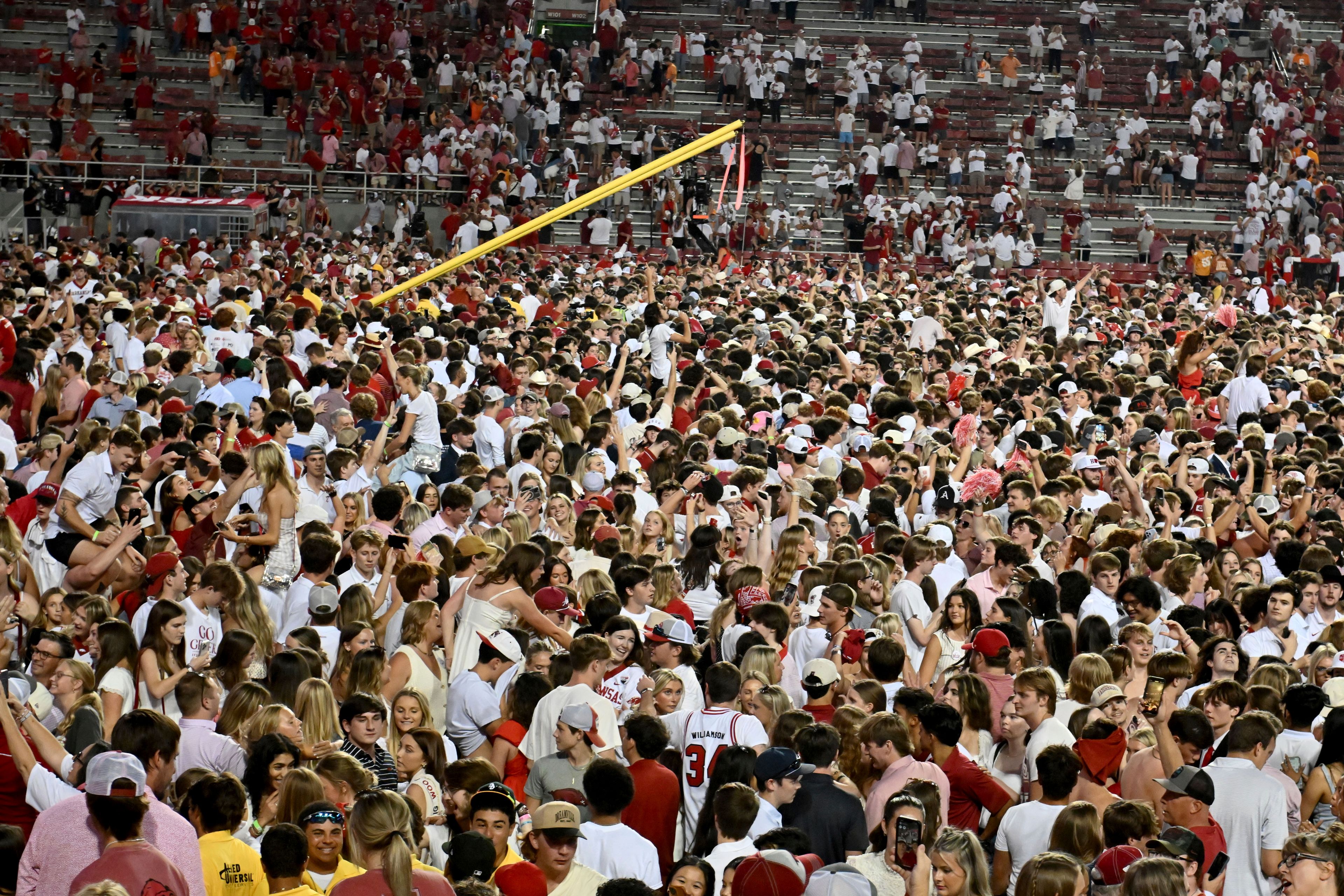 Arkansas fans rush the field to celebrate after Arkansas upsets Tennessee 19-14 during an NCAA college football game, Saturday, Oct. 5, 2024, in Fayetteville, Ark. (AP Photo/Michael Woods)