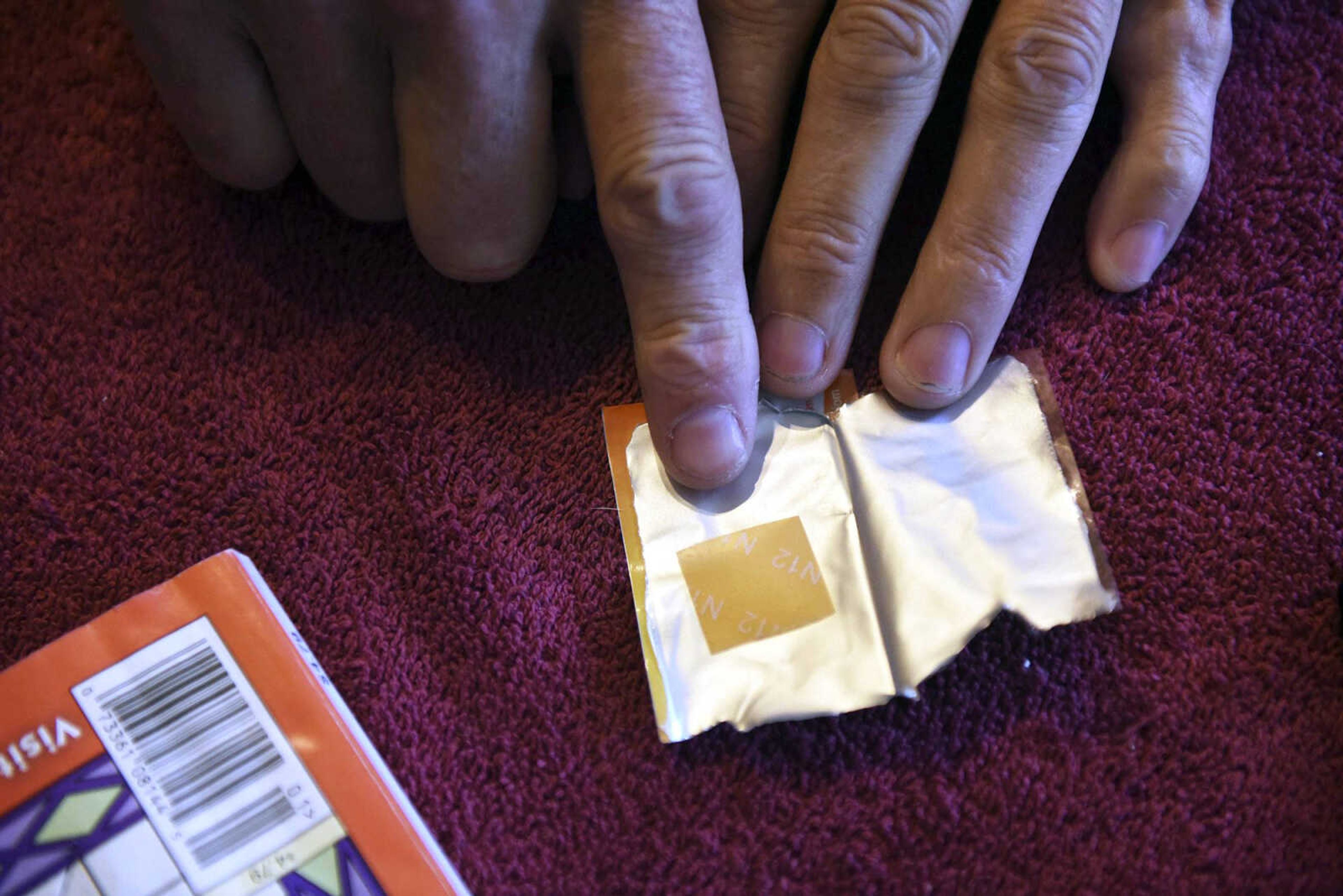 Denny Sercu points to his daily dose of Suboxone, a medication that lowers withdrawal symptoms and craving, on Nov. 17 while in his home in Boonville, Missouri.