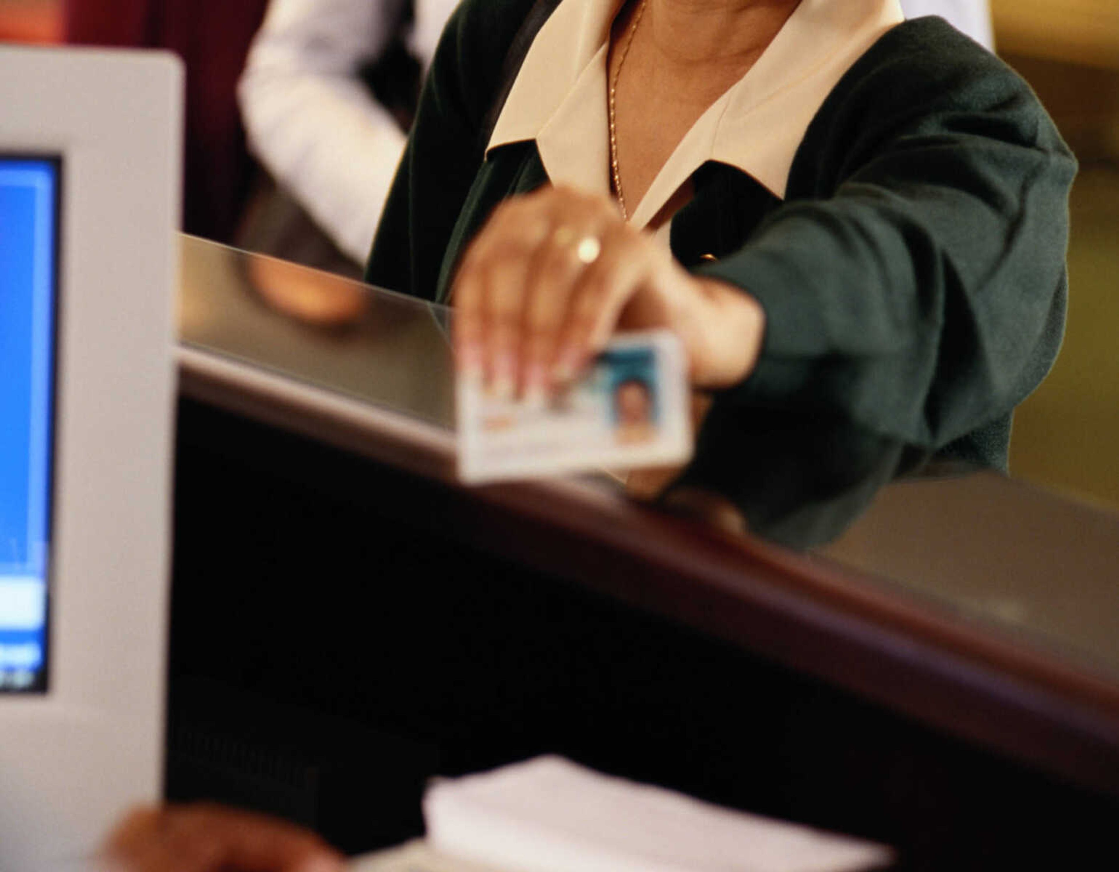 Woman presenting identification at bank (focus on woman)