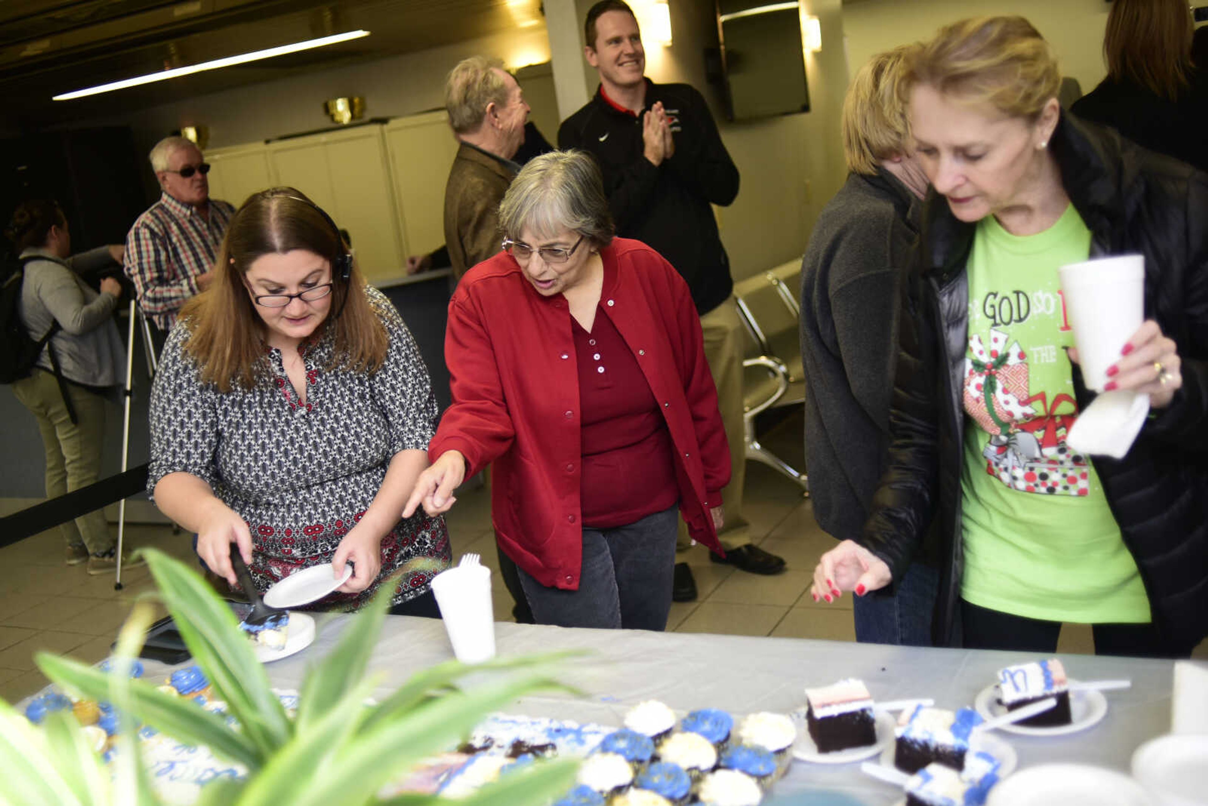 People eat cake and cupcakes during the inaugural trip to Chicago on a CRJ200 airplane with SkyWest Friday, Dec. 1, 2017 at Cape Girardeau Regional Airport in Cape Girardeau.