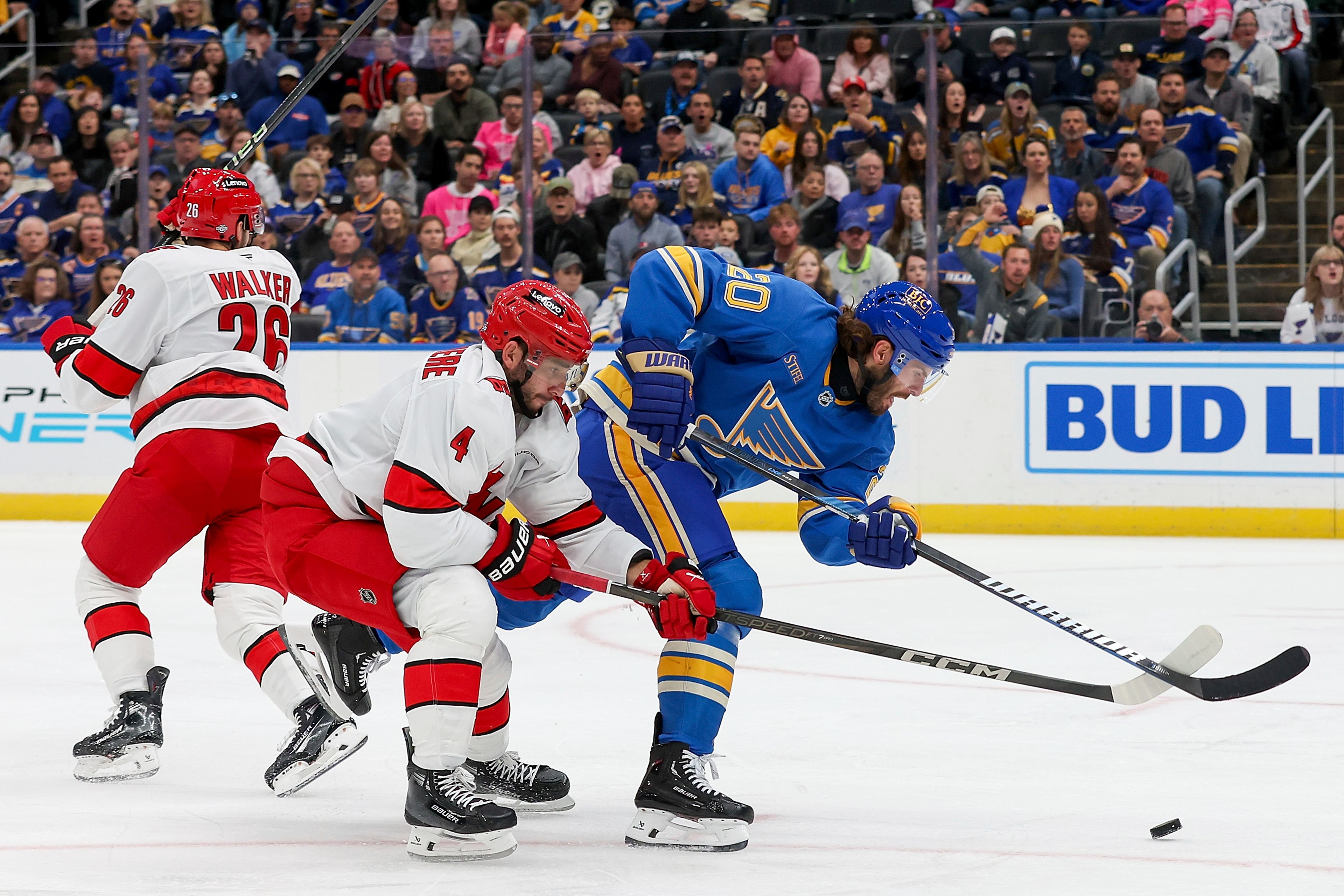 Carolina Hurricanes' Shayne Gostisbehere (4) and St. Louis Blues' Brandon Saad (20) vies for control of the puck during the second period of an NHL hockey game Saturday, Oct. 19, 2024, in St. Louis. (AP Photo/Scott Kane)