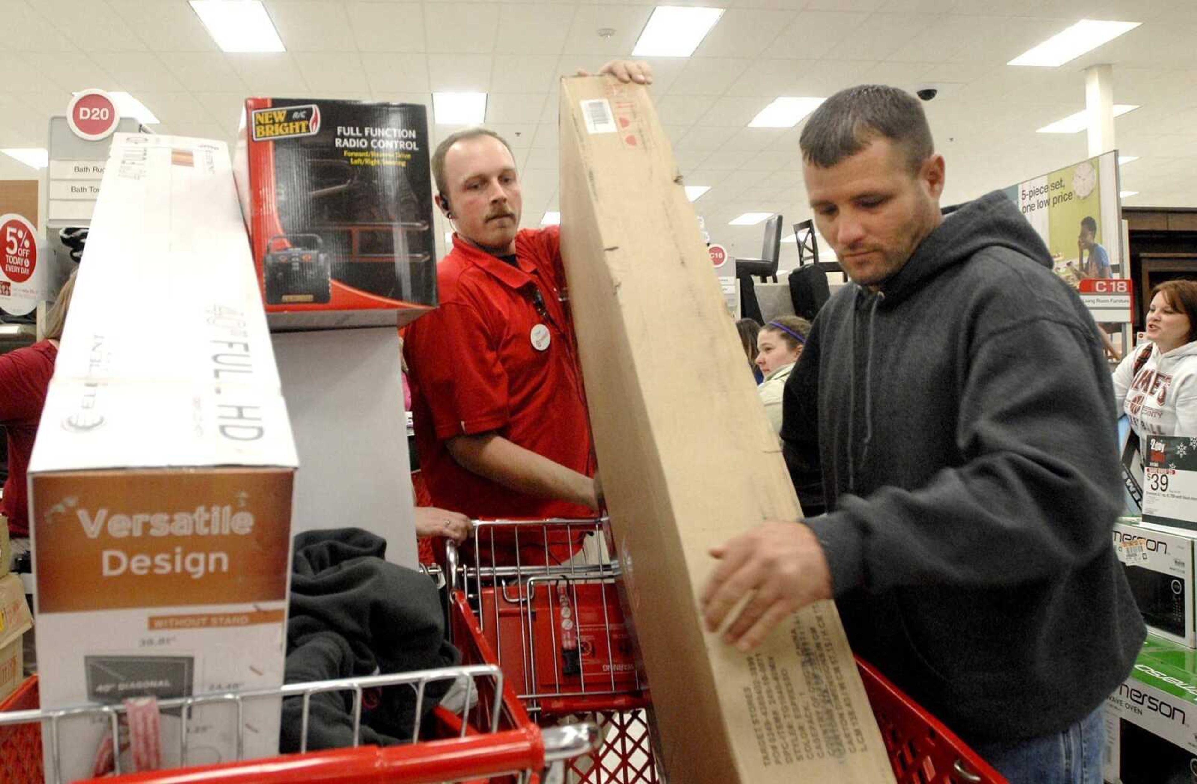 LAURA SIMON ~ lsimon@semissourian.com
Target employee Drew Goodman assists Colin Grissom of East Prairie, Mo. with a television stand during Black Friday at Target in Cape Girardeau. Grissom waited in line four hours for a deal on a television and stand.