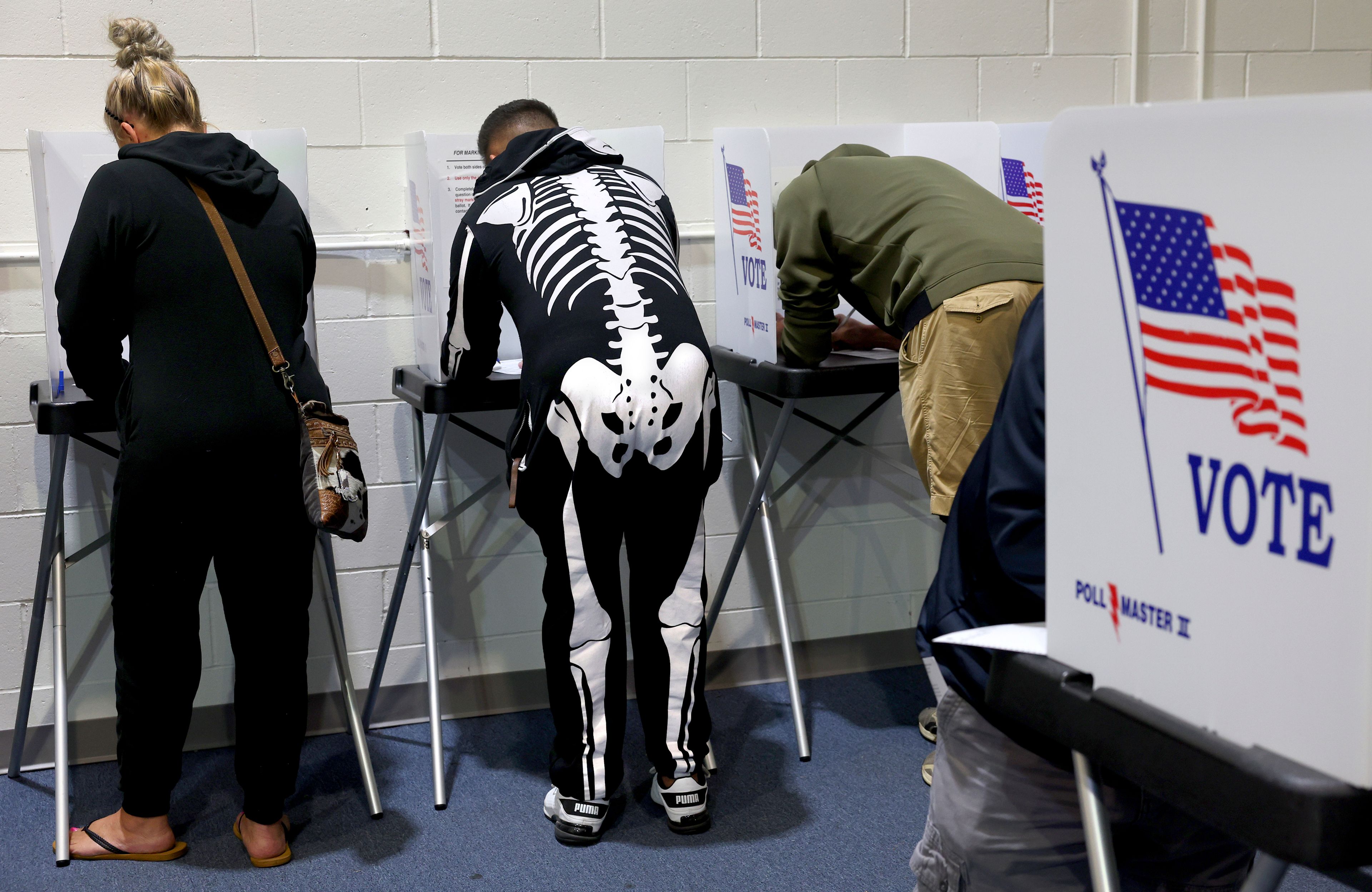 Ready for Halloween, Mark Reynolds, center, votes early beside his wife Jennifer, left, at the St. Charles County Election Authority in St. Charles, Mo. on Thursday, Oct. 31, 2024. (Robert Cohen/St. Louis Post-Dispatch via AP)