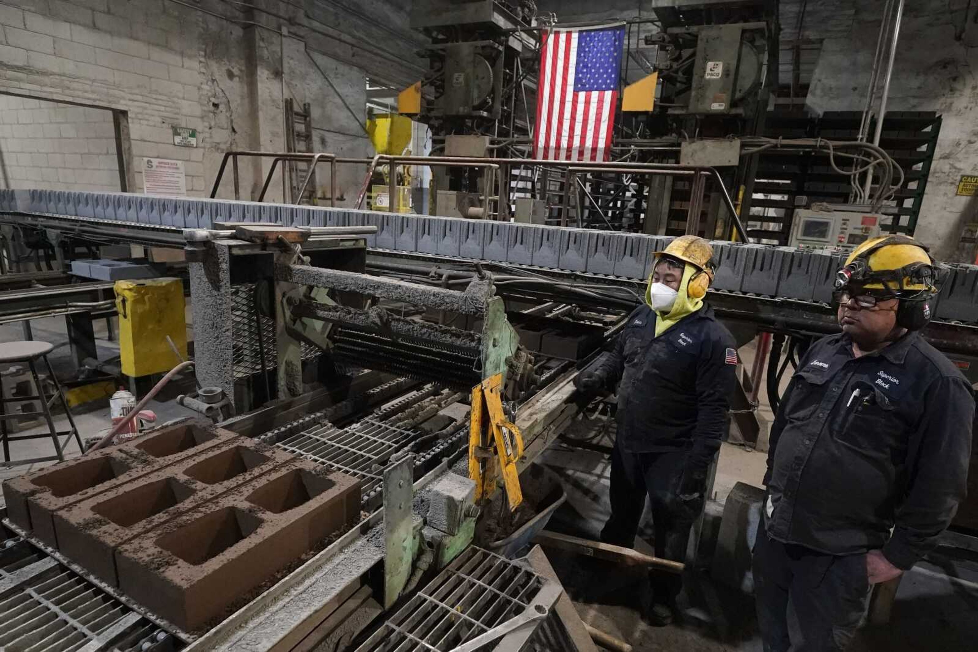 Workers monitor a production line of concrete blocks created with liquid carbon dioxide as an ingredient at the Glenwood Mason Supply Co. on April 18 in the Brooklyn borough of New York.