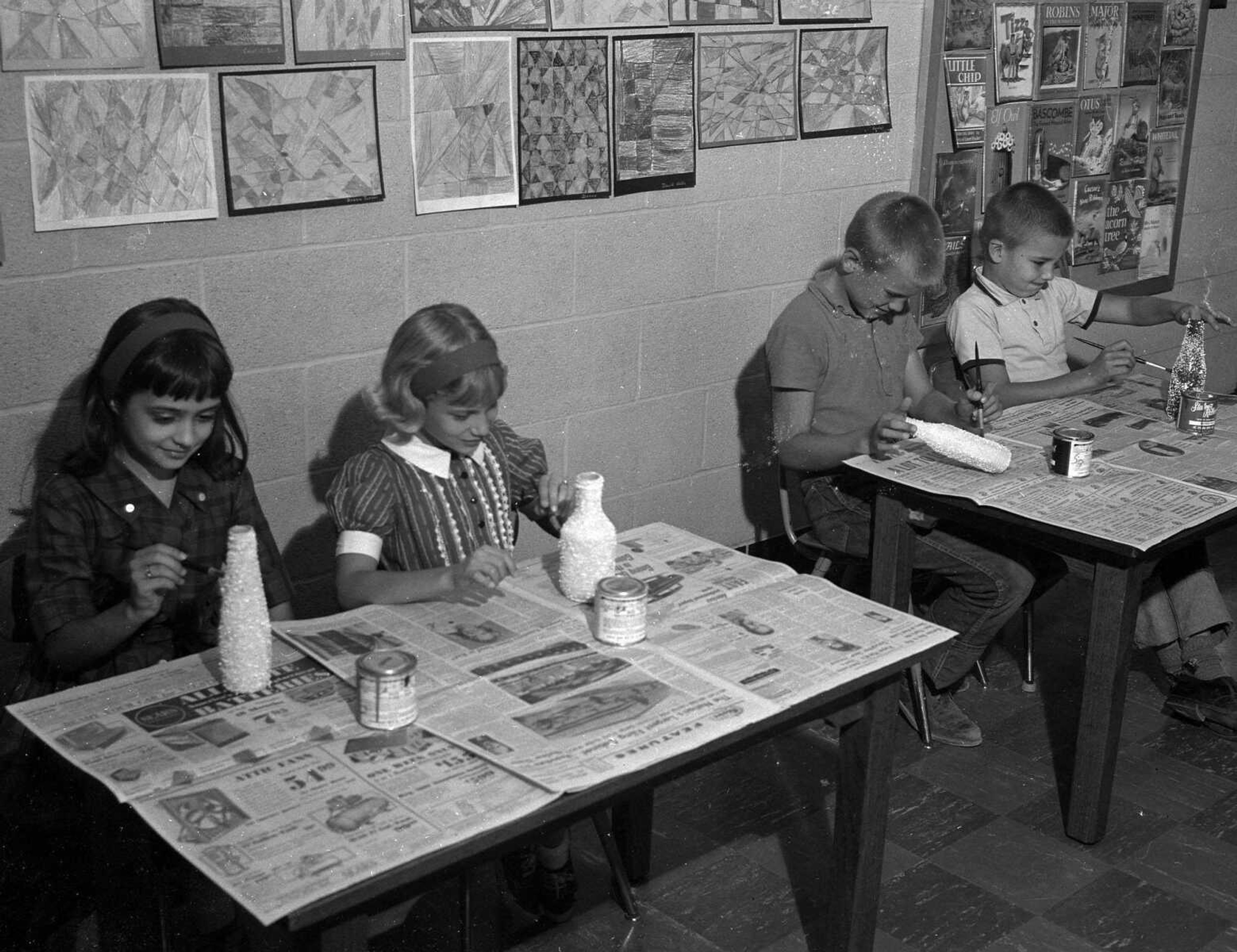 Oct. 5, 1963 Southeast Missourian.
Third grade pupils at Trinity Lutheran School busy themselves making vases. At work painting their vases are, from left, Debbie Hoeller, Linda Warner, Hunter Stiegemeyer and Wayne Sprengel. Miss Ruth Froemsdorf is their teacher. (G.D. Fronabarger/Southeast Missourian archive)
Miss Froemsdorf told her pupils to bring some bottles to class for a new project. Some of her pupils brought catsup bottles, others milk bottles and various shaped bottles.
Crushed eggshells, dried and broken into fine pieces, were glued onto the bottles. The bottles were then painted various colors with enamel. The results: beautiful and glittering vases.