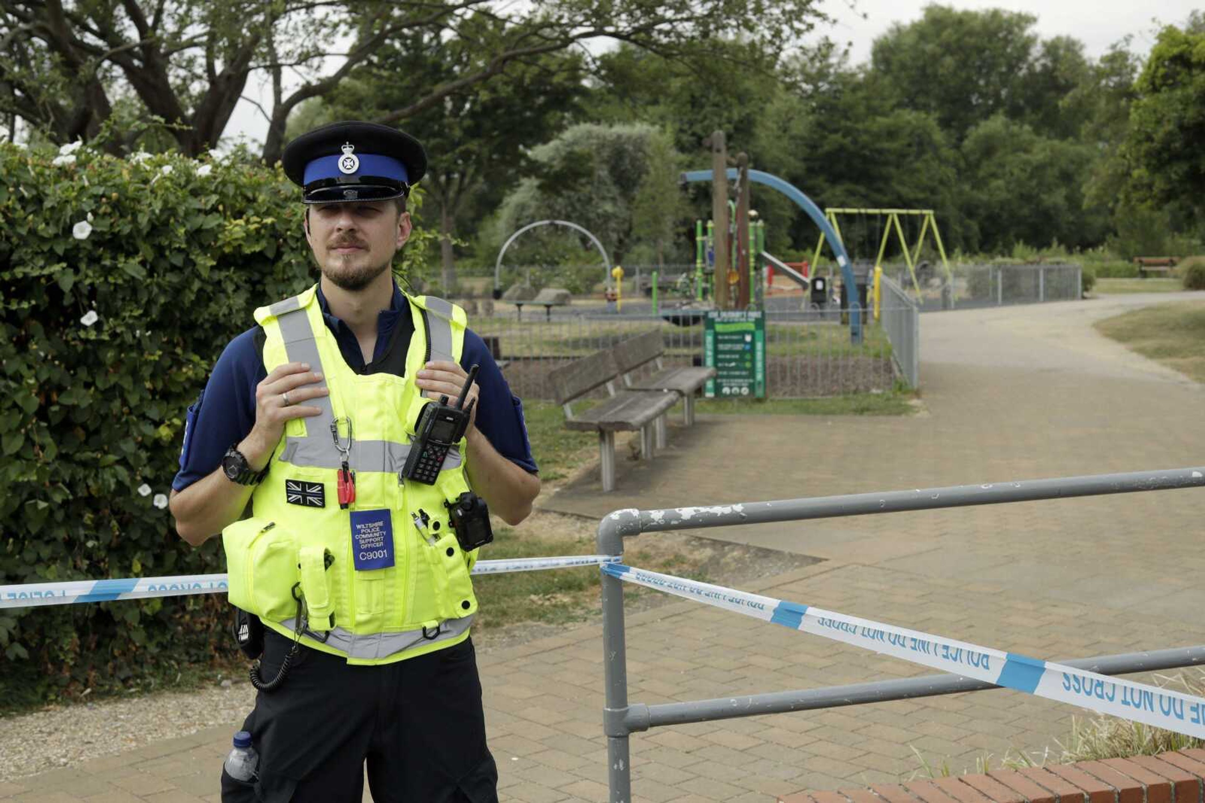 A British police community support officer guards a cordon Thursday outside the Queen Elizabeth Gardens park in Salisbury, England. British officials are seeking clues in the rush to understand how two Britons were exposed to the military-grade nerve agent Novichok.