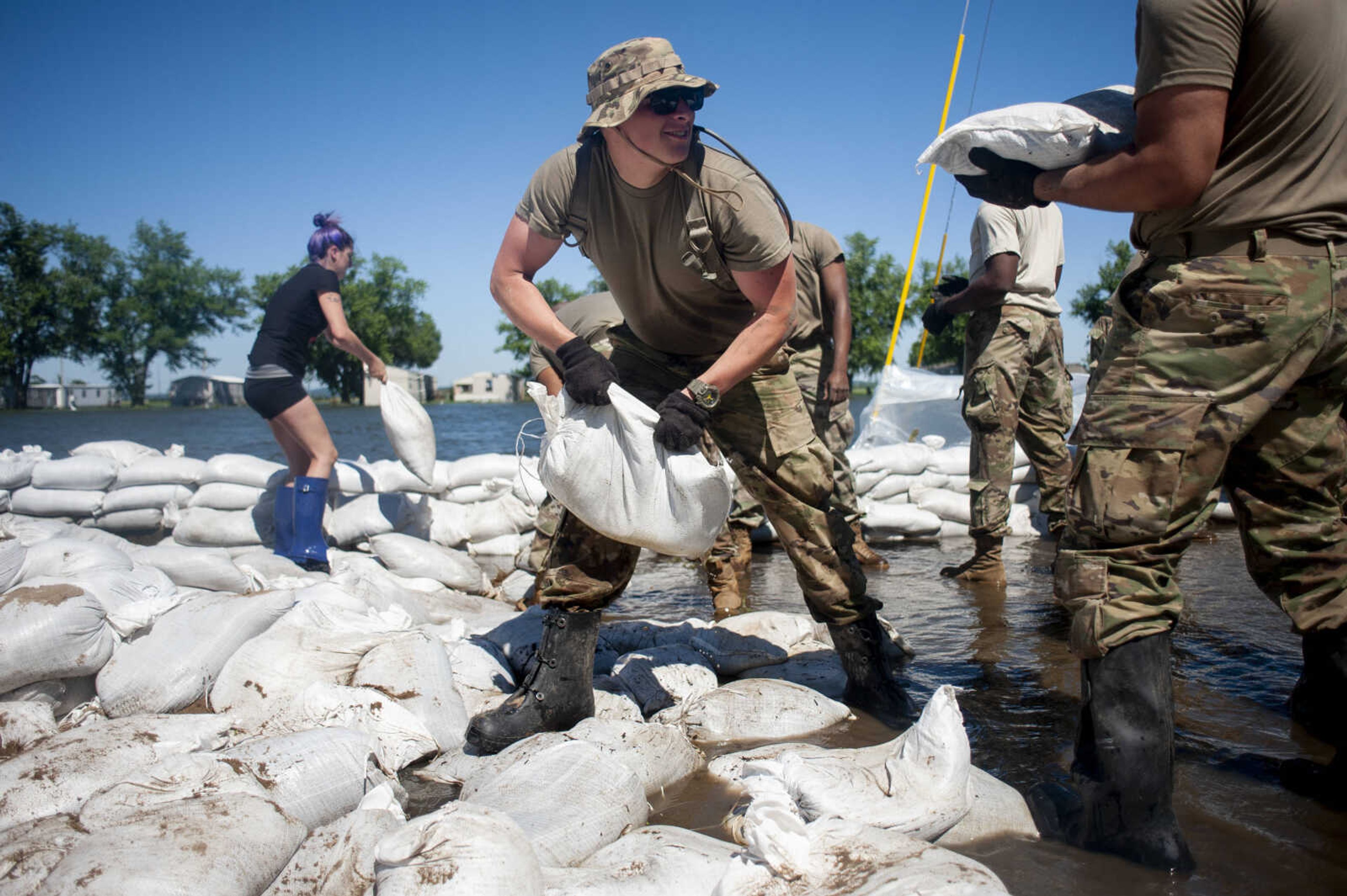 Illinois National Guard member Michael Sheppard helps other Guard members build up existing sandbag barriers to hold back floodwaters Monday, June 10, 2019, along Brookwood Drive in East Cape Girardeau, Illinois.