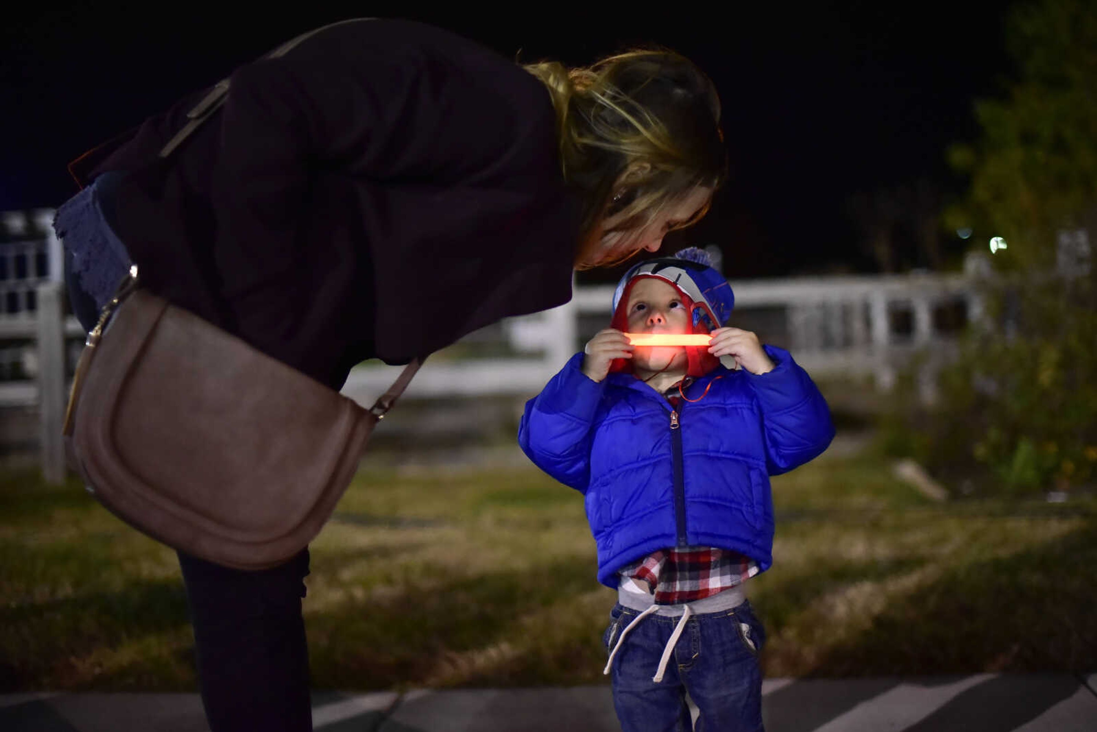 Xavier Mueth, 2, places his mouth near his glow stick with his mother Amanda Mueth during the Fall Family Festival Friday, Nov. 17, 2017 at the Shawnee Park Center in Cape Girardeau.