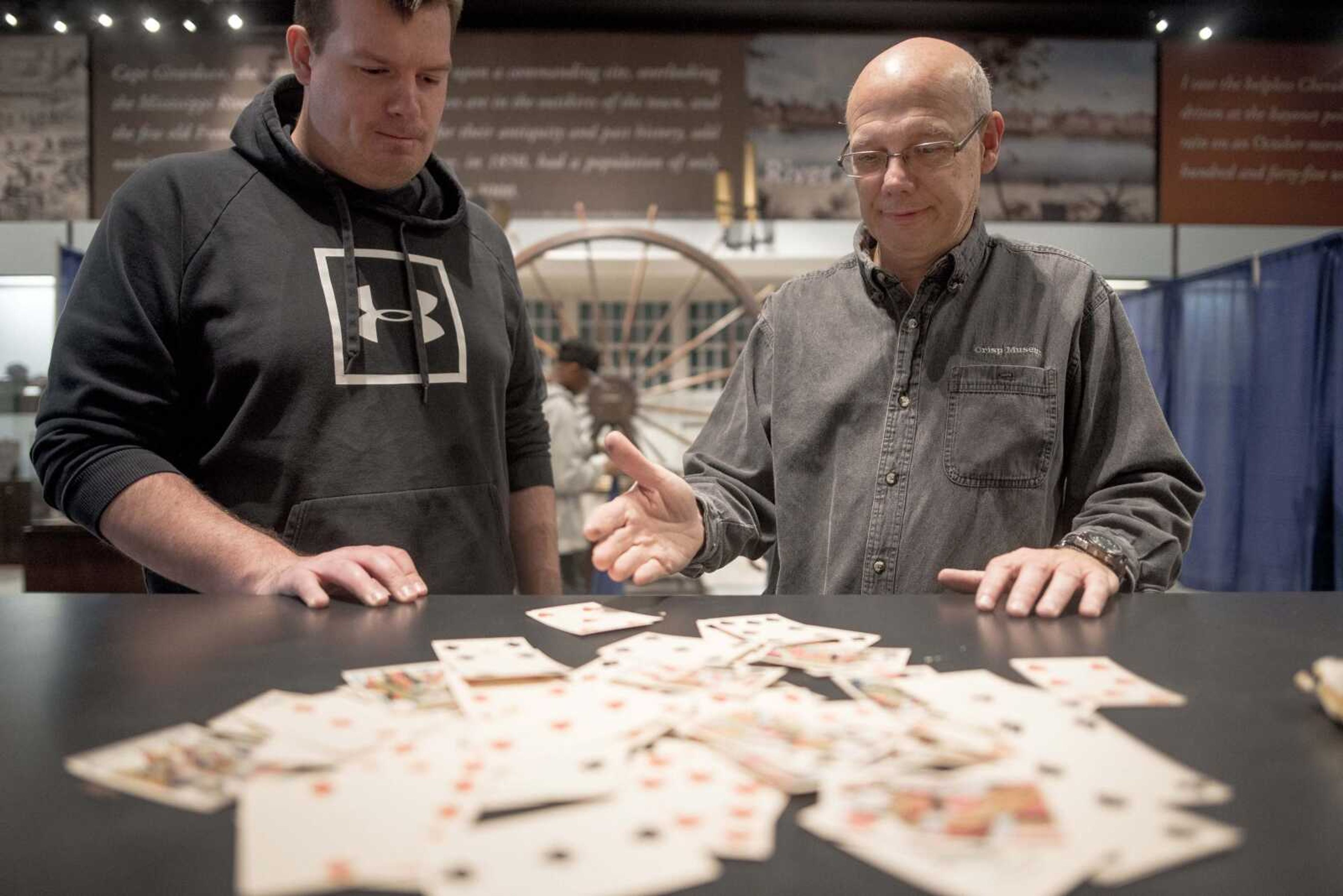 Crisp Museum outreach specialist Gary Tyler, right, and volunteer Nathan Walker discuss a replica deck of antique cards (one of which is missing) as part of an escape-room style activity Nov. 15, 2019, at the Southeast Missouri State University River Campus in Cape Girardeau.