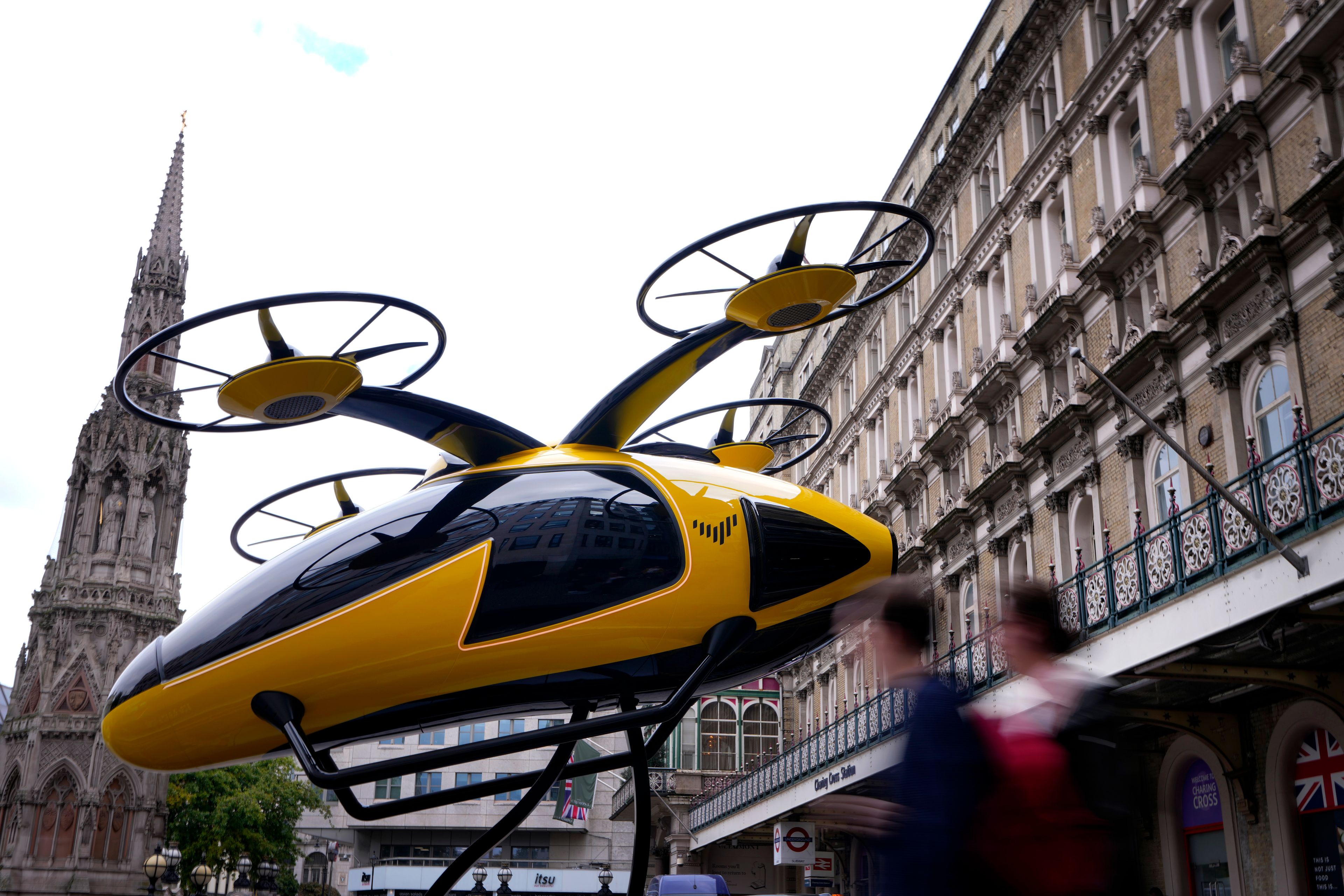 Pedestrians pass a prototype of a flying taxi, which is currently in development in the United Arab Emirates (UAE), after it was unveiled in the taxi rank outside Charing Cross railway station in London, Wednesday, Oct. 9, 2024. (AP Photo/Kirsty Wigglesworth)