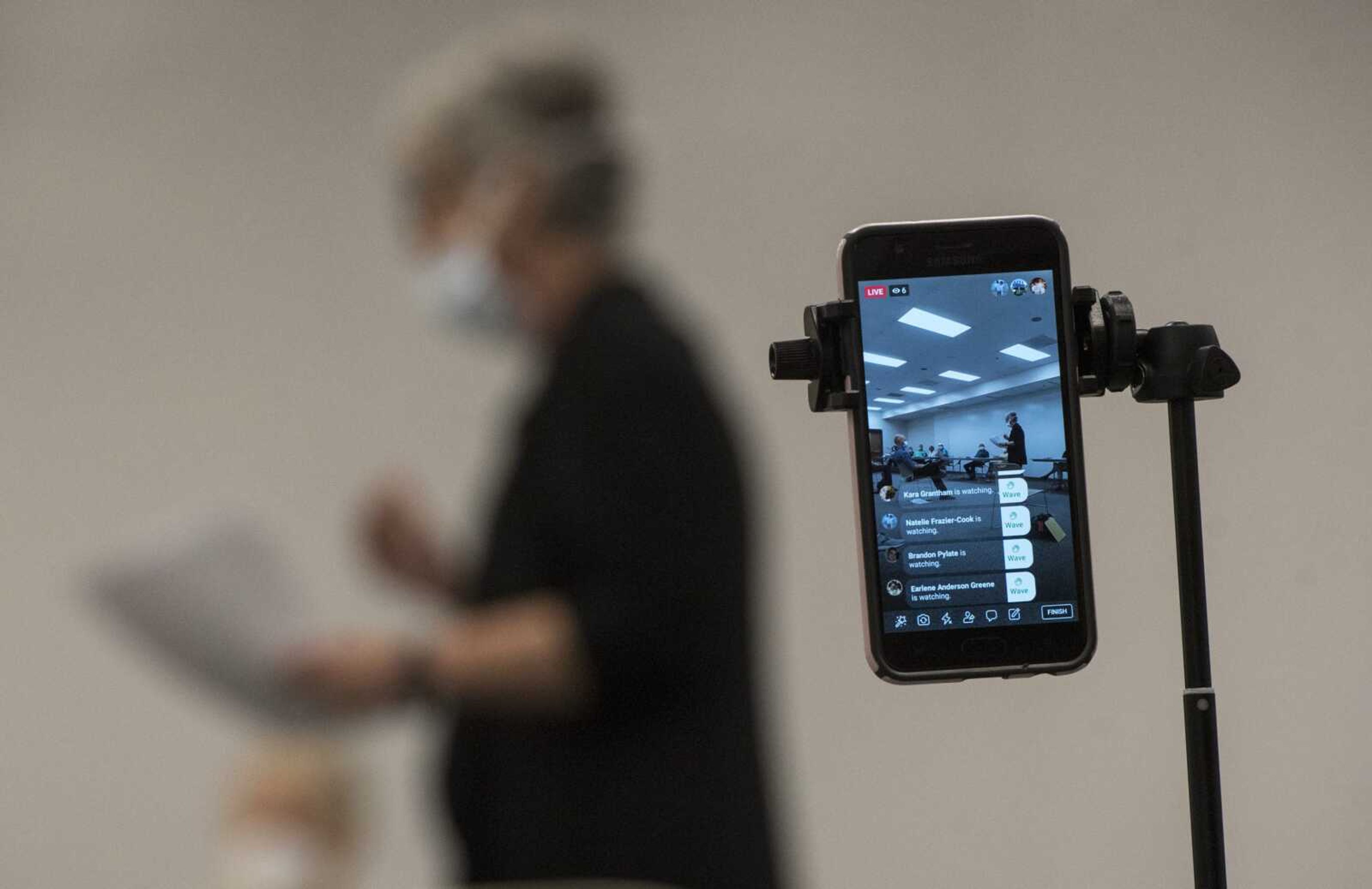 An attendee broadcasts a Facebook Live video as Rita LaVanchy criticizes the Cape Girardeau Public Health Center's mask mandate during a Board of Trustees meeting Tuesday at the Osage Centre in Cape Girardeau.