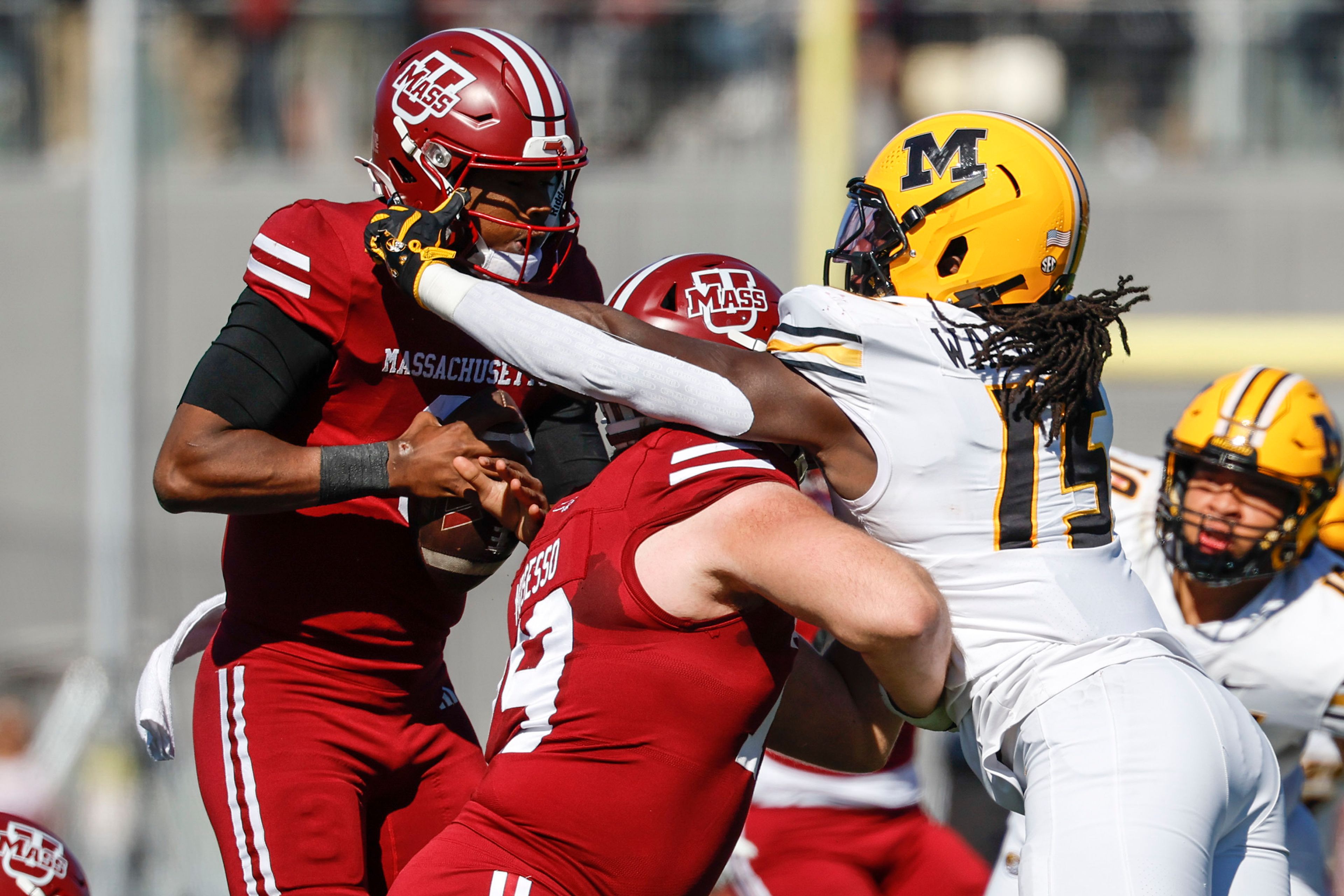 Missouri defensive end Johnny Walker Jr. (15) reaches over Massachusetts offensive lineman Ryan Mosesso (79) to touch the helmet of quarterback Taisun Phommachanh (3) during the first half of an NCAA football game, Saturday, Oct. 12, 2024, in Amherst, Mass. (AP Photo/Greg M. Cooper)