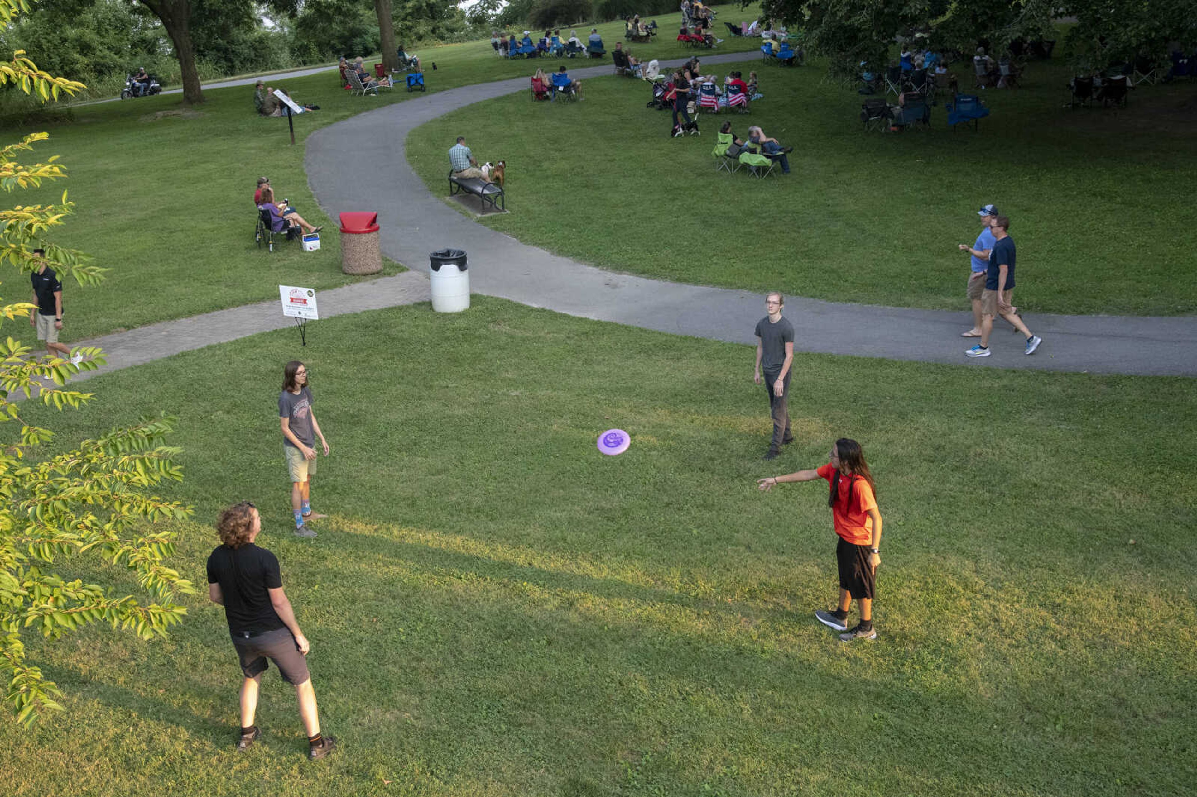 People throw a flying disc as Anne McCue performs during Tunes at Twilight at the River Campus Friday Aug. 6, 2021.