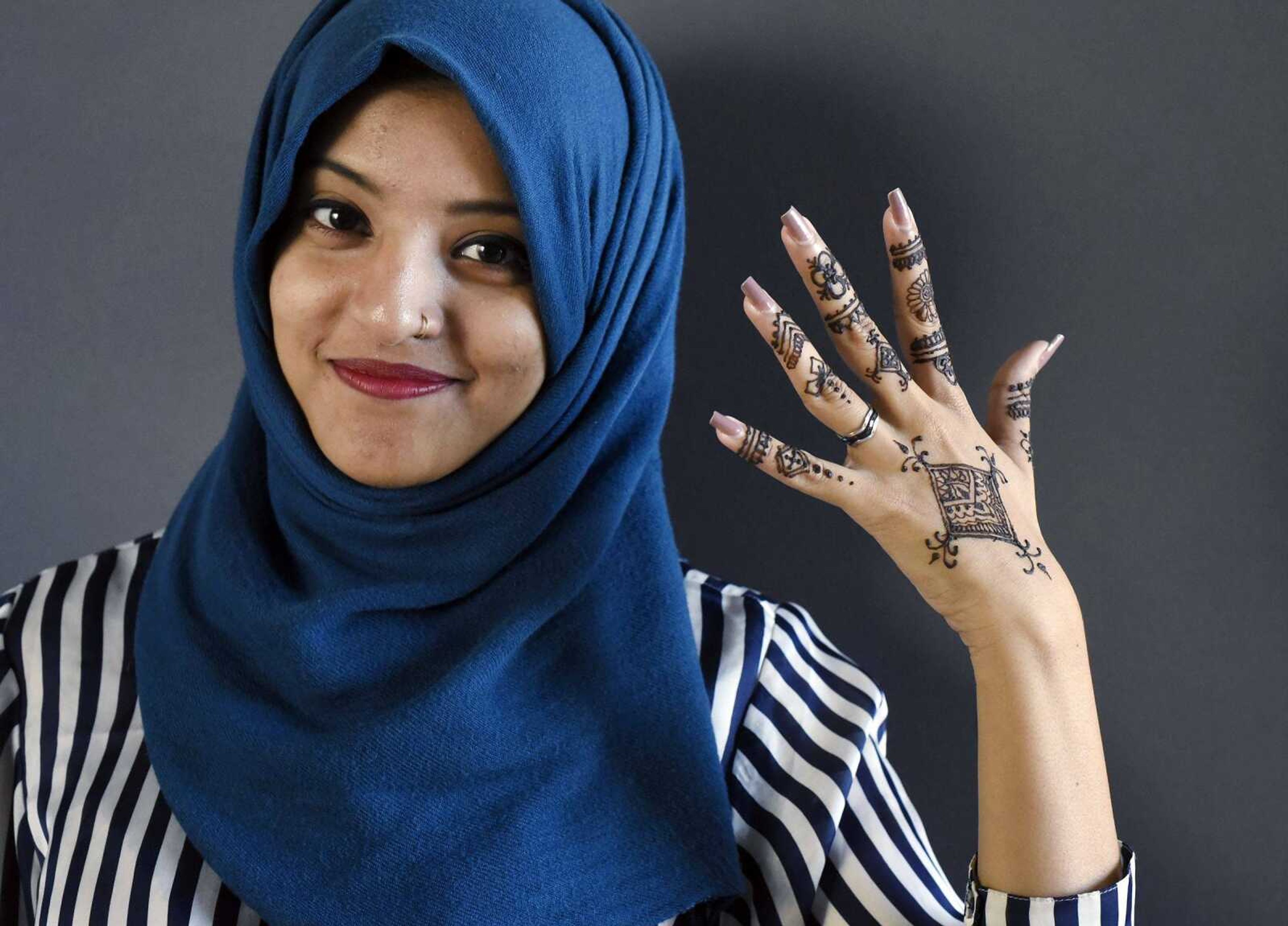 Iffat Ara poses for a portrait after applying henna to her left hand on Friday, March 10.