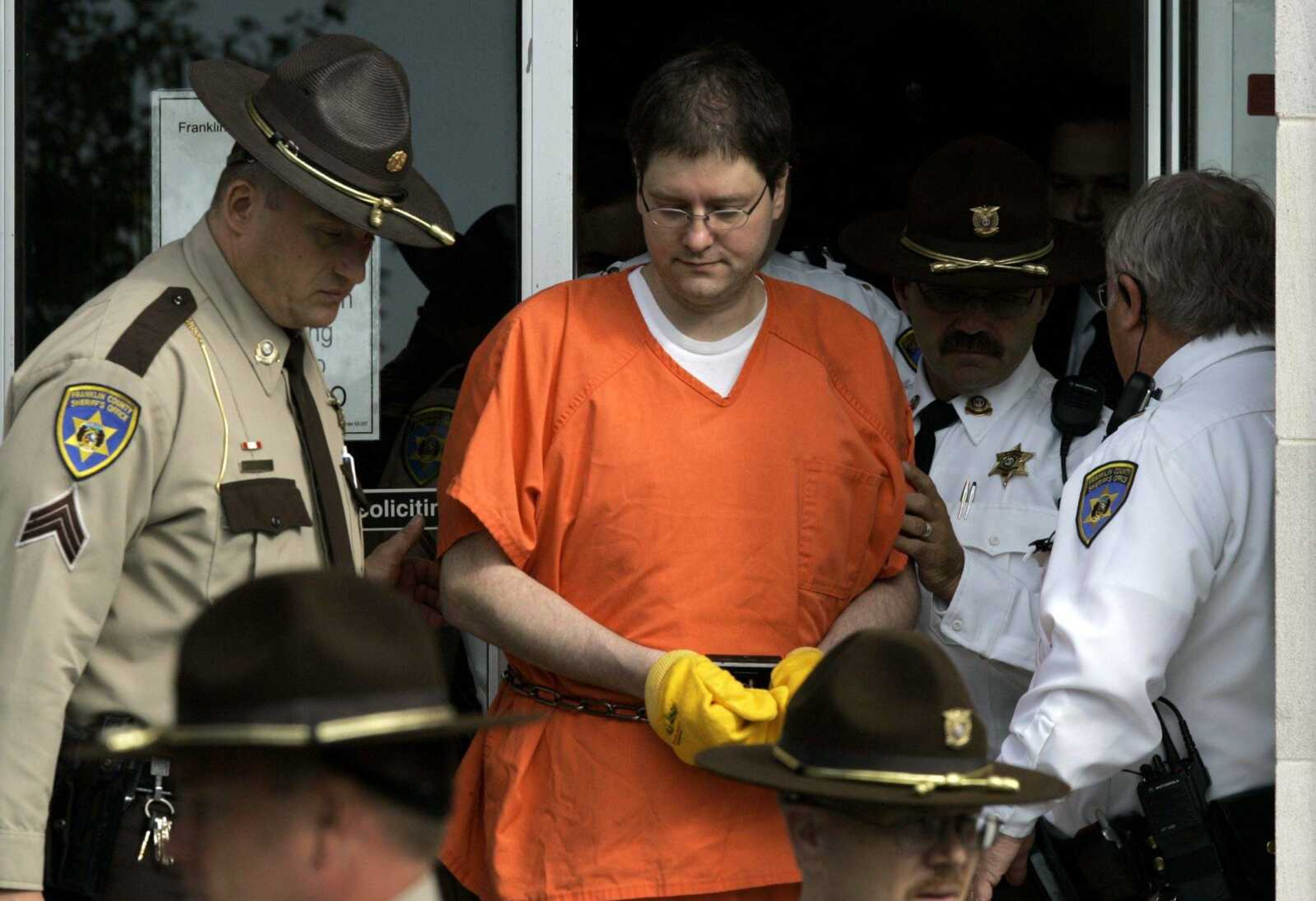 Michael Devlin is escorted out of the Franklin County Courthouse under heavy security Oct. 8, 2007, in Union, Missouri.