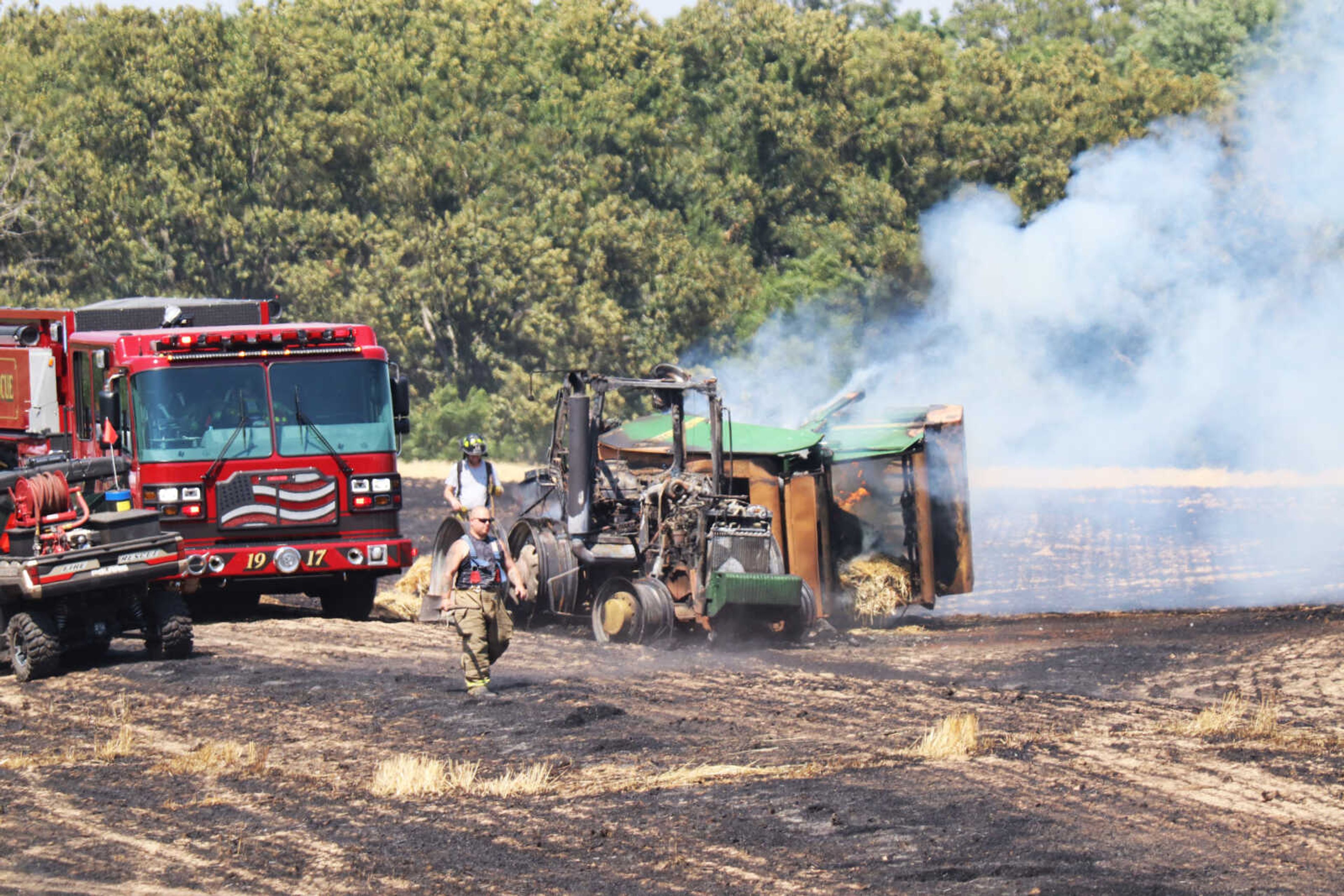 Perry County firefighters attend to a burning baler and tractor after putting out fires in the surrounding hayfields Monday, June 26, in Perry County at 347 Trails End Lane. According to Perry County Sheriff Jason Klaus, the fire was started when a baler caught on fire, which then spread to the tractor and the surrounding hayfield. It took an hour for the Perry County Fire Department along with aid from fire departments in Chester, Illinois, and Ste. Genevieve, Missouri, to put out the fire.