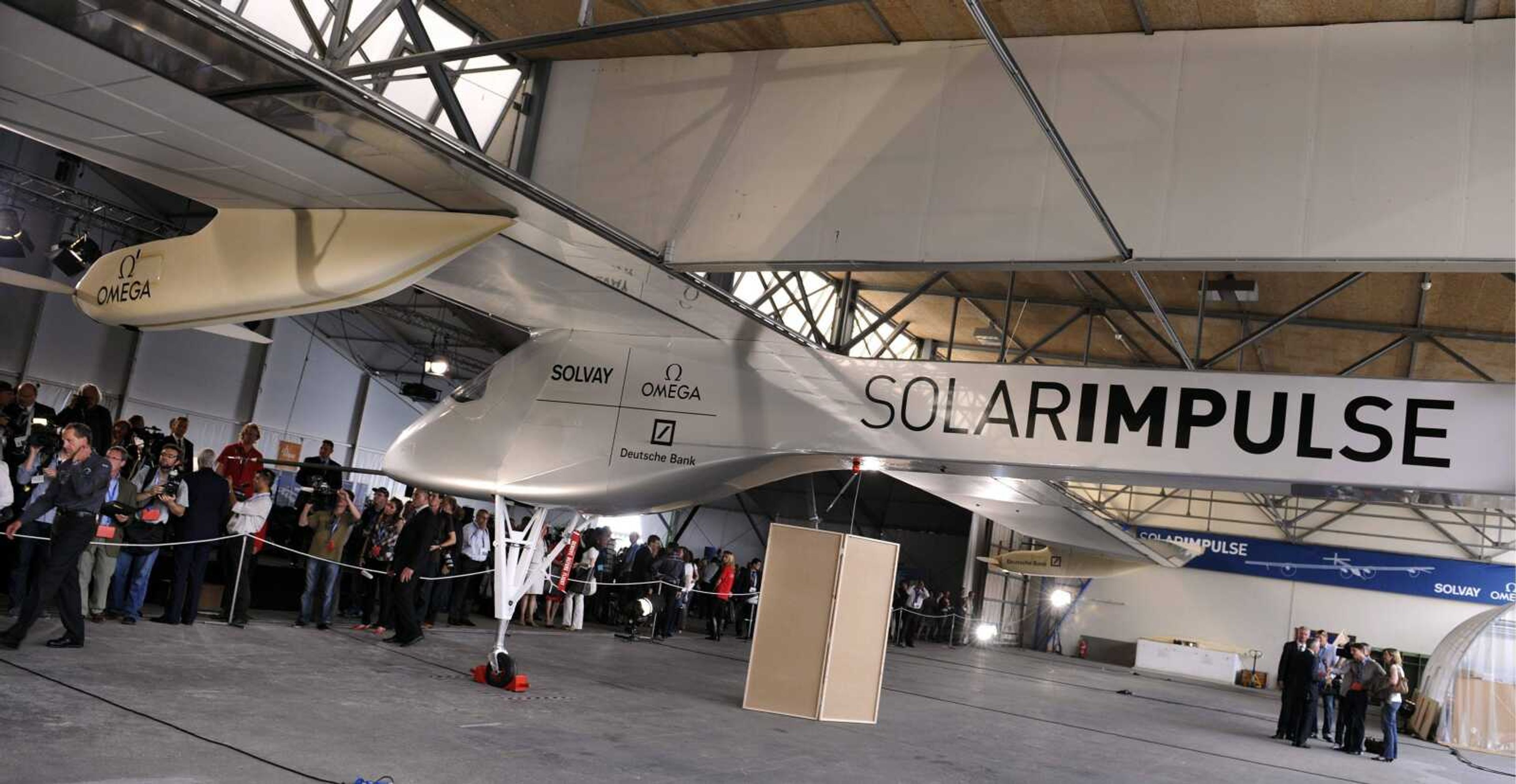 People watch the Solar Impulse HB-SIA, the first solar airplane aiming to fly night and day withhout fuel, on Friday in Duebendorf Airfield, Switzerland. (WALTER BIERI ~ Associated Press)