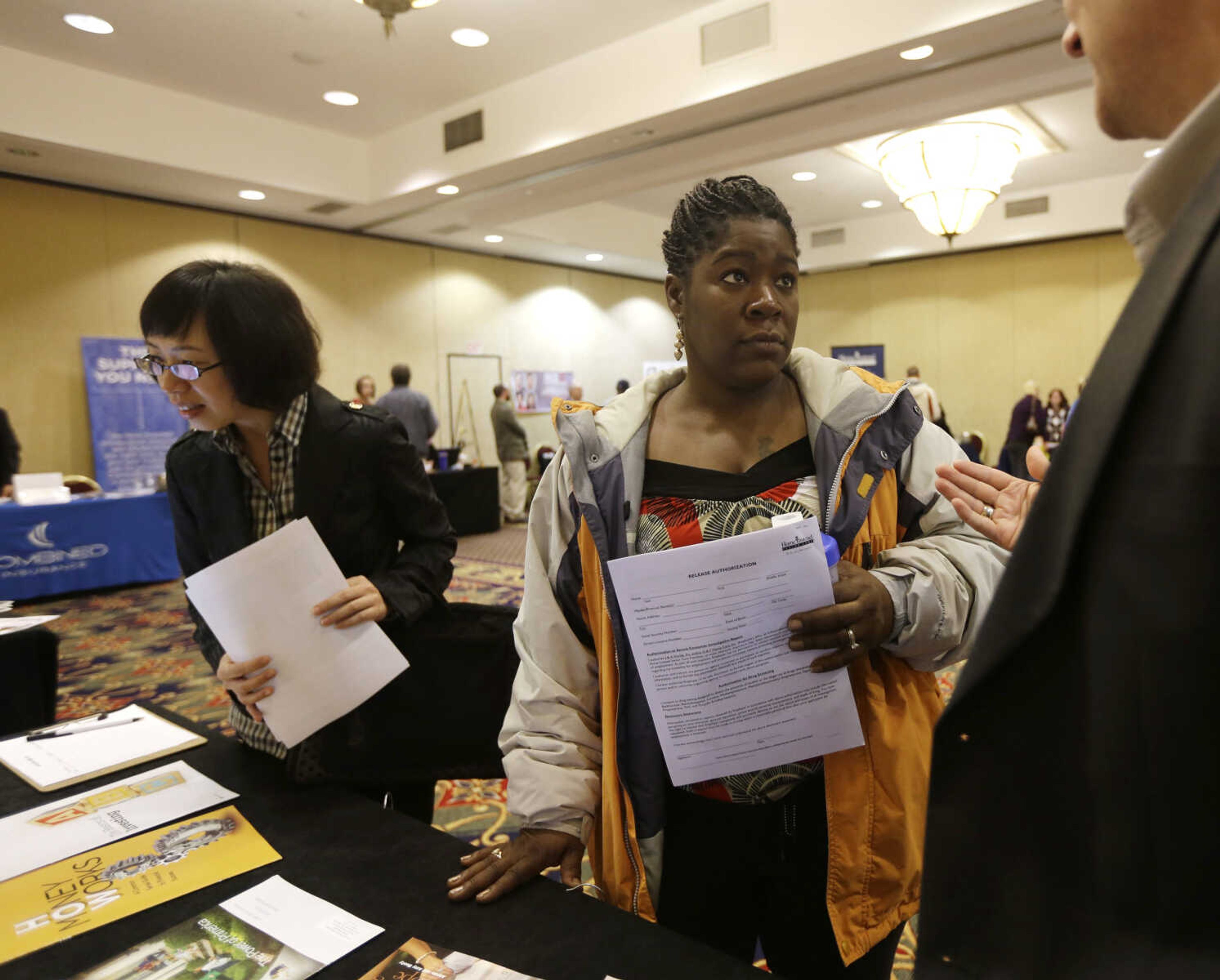 In this Thursday, Oct. 25, 2012, photo, Angela Winters of Schenectady, N.Y., center, talks to a recruiter during a job fair at the Marriott Hotel on ,in Colonie, N.Y. The number of people seeking U.S. unemployment aid remained elevated for a second straight week because Superstorm Sandy forced many people to seek temporary benefits. The Labor Department said Wednesday, Nov. 21, 2012,  that first-time applications for benefits fell by 41,000 last week to a seasonally adjusted 410,000. That offset only part of the previous week's surge.(AP Photo/Mike Groll)