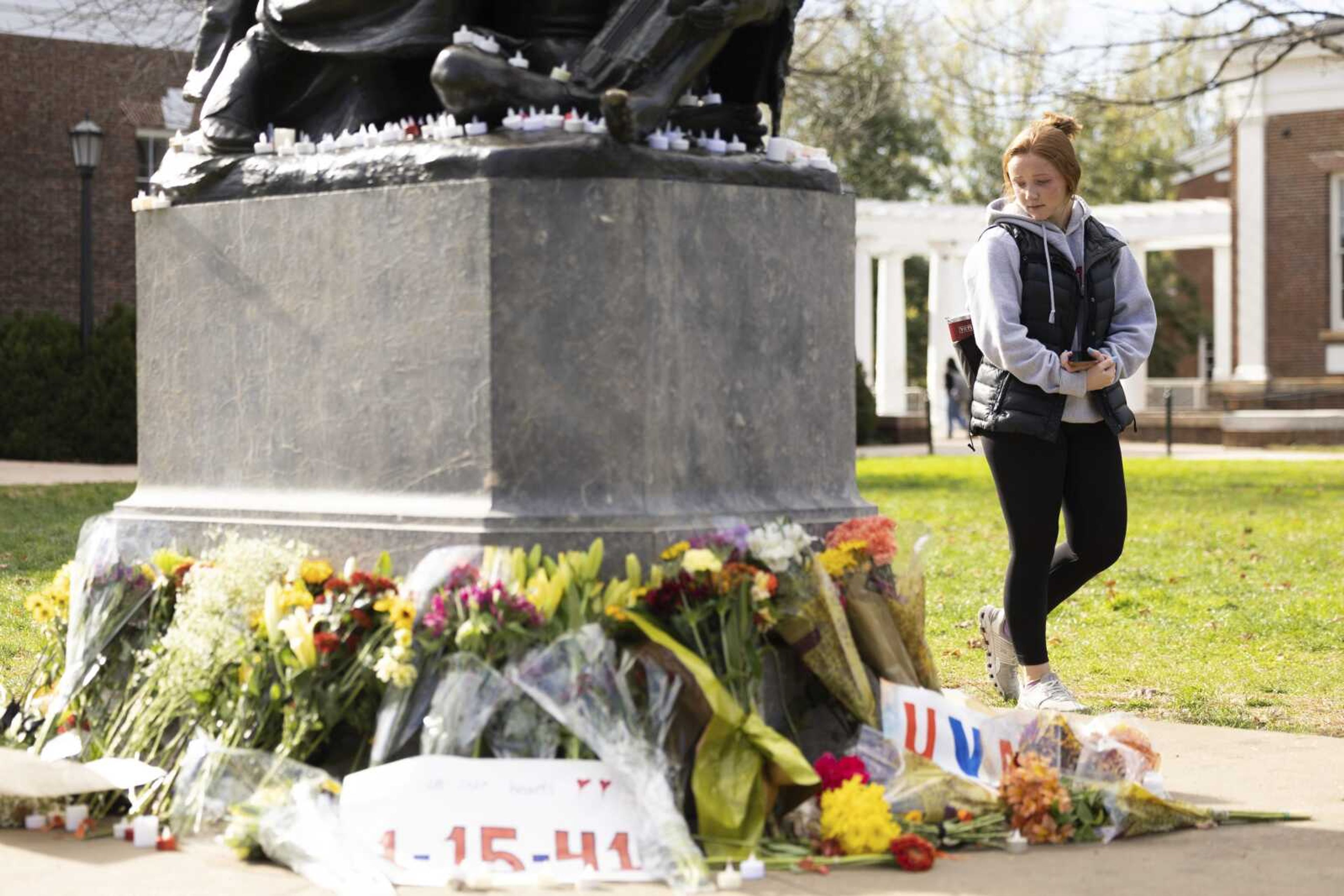 Meredith Flattum, a second year biology student at the University of Virginia, visits a memorial Wednesday, Nov. 16, to three students who were killed in Charlottesville, Virginia.